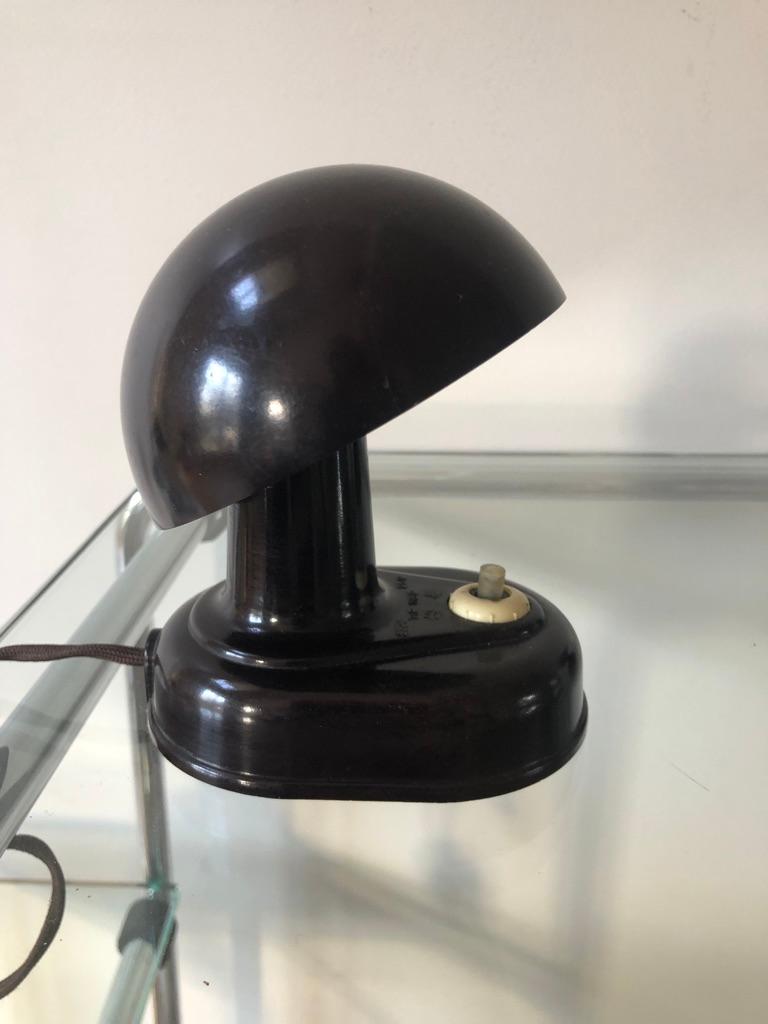 A pair available of this tiny brown bakelite lamp that can be both table or wall lights. A typical simple yet very clever design of the Czechoslovakian Art Deco period which with its articulated shade clipped on the light bulb enables to cast the