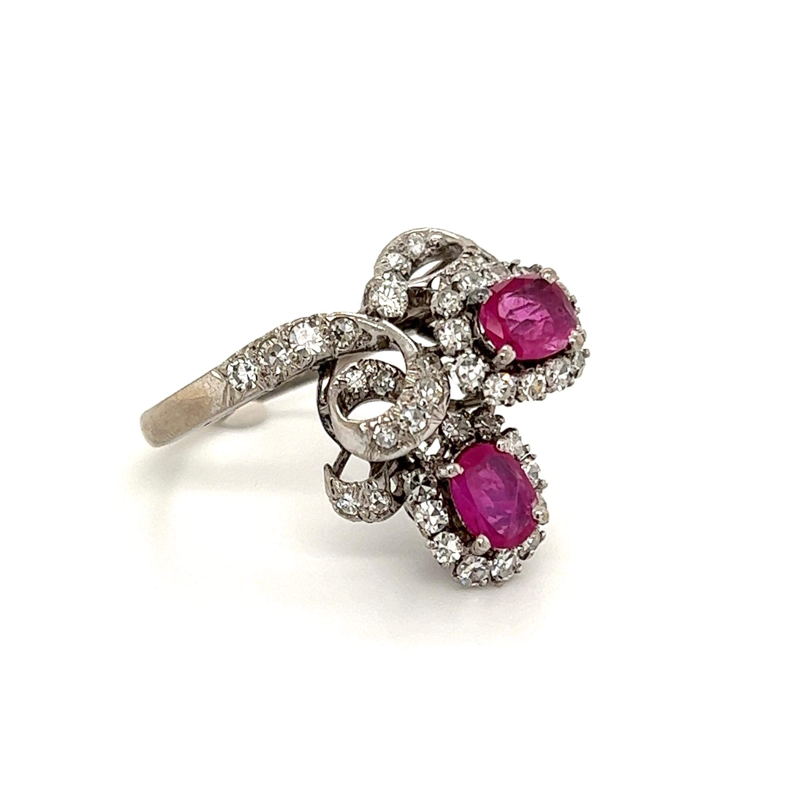 Simply Beautiful! Finely crafted 2-Stone Ruby and Diamond Cluster Ring. Securely Hand set with 2 oval Rubies, weighing approx. 1.50tcw, surrounded by 44 Single cut Diamonds weighing approx. 1.10tcw. Dimensions 1.11