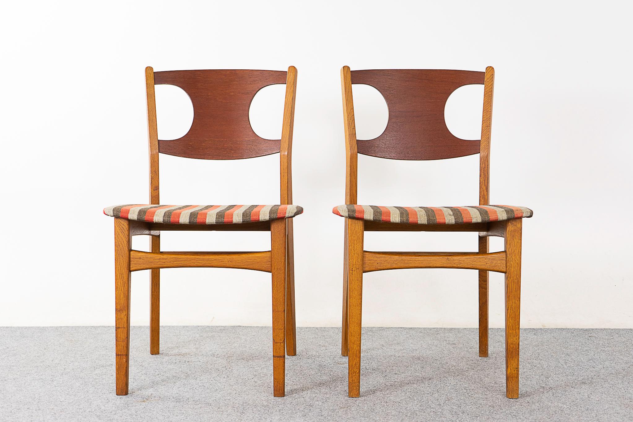 Teak and oak dining chair pair by Paul Rasmussen, circa 1960's. Unique cutout design on the teak curved backrests, robust solid oak frame with bowtie cross bars. Original fabric with wear & tear, removable seat pad makes reupholstering a snap! 