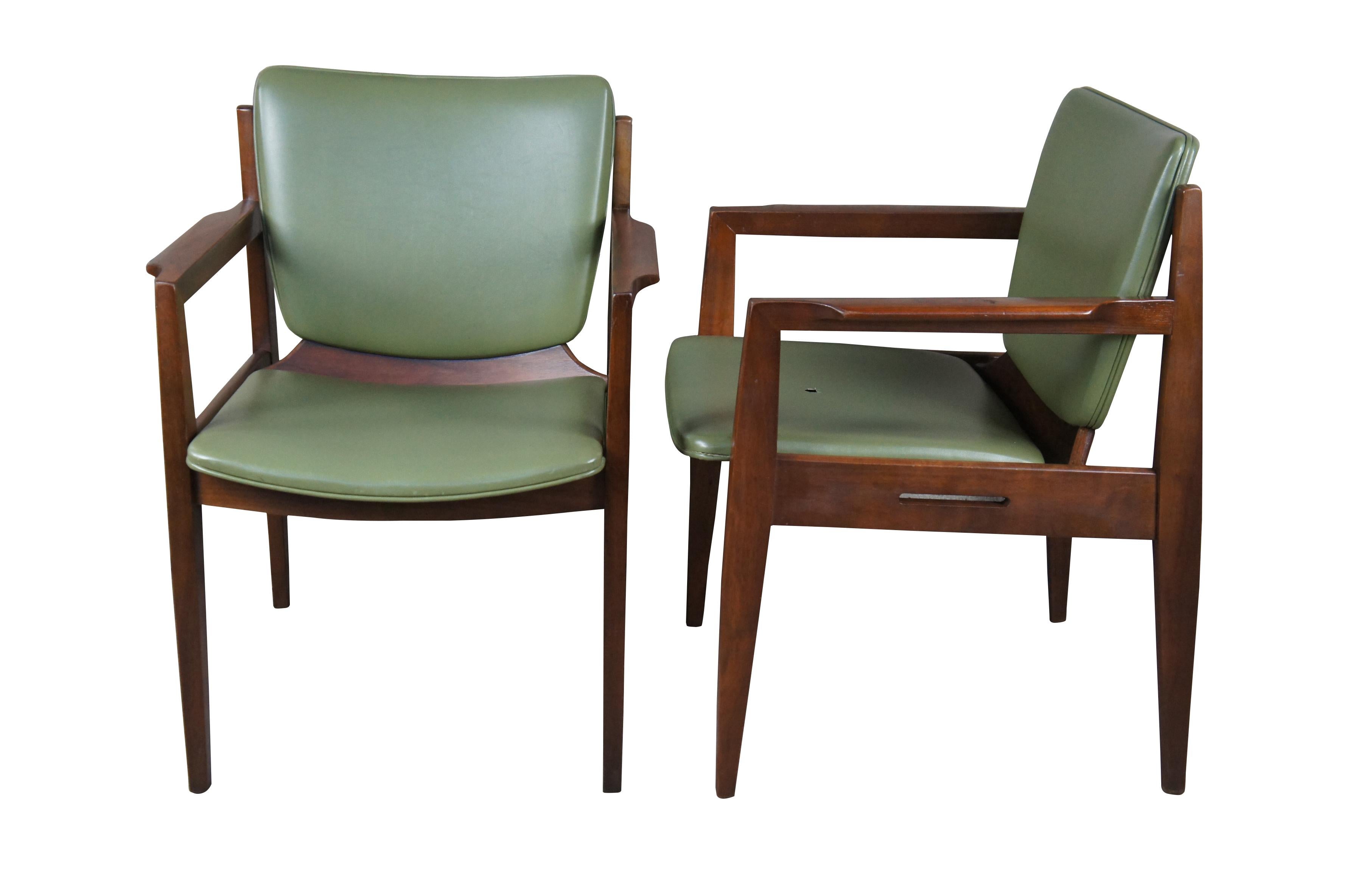 Pair of Thonet arm chairs, circa 1960s. Features Danish styling with streamline modern frames and original green vinyl fabric. Tag along underside.