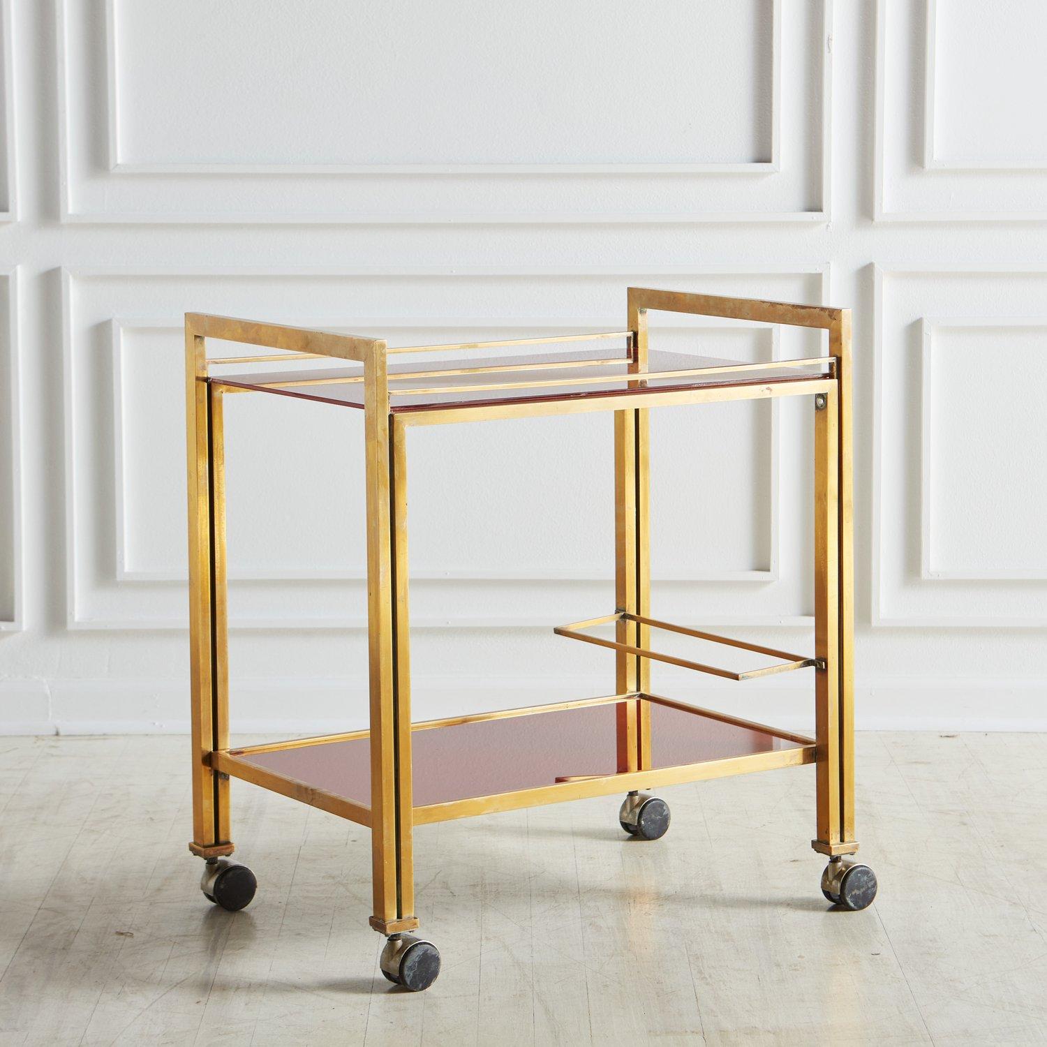 n elegant two-tier patinated brass with red glass shelves bar cart by Guy Lefevre for Maison Jansen. The combination of materials and the straight lines give this bar cart a modern look. And the unique red glass makes this bar cart the life of any