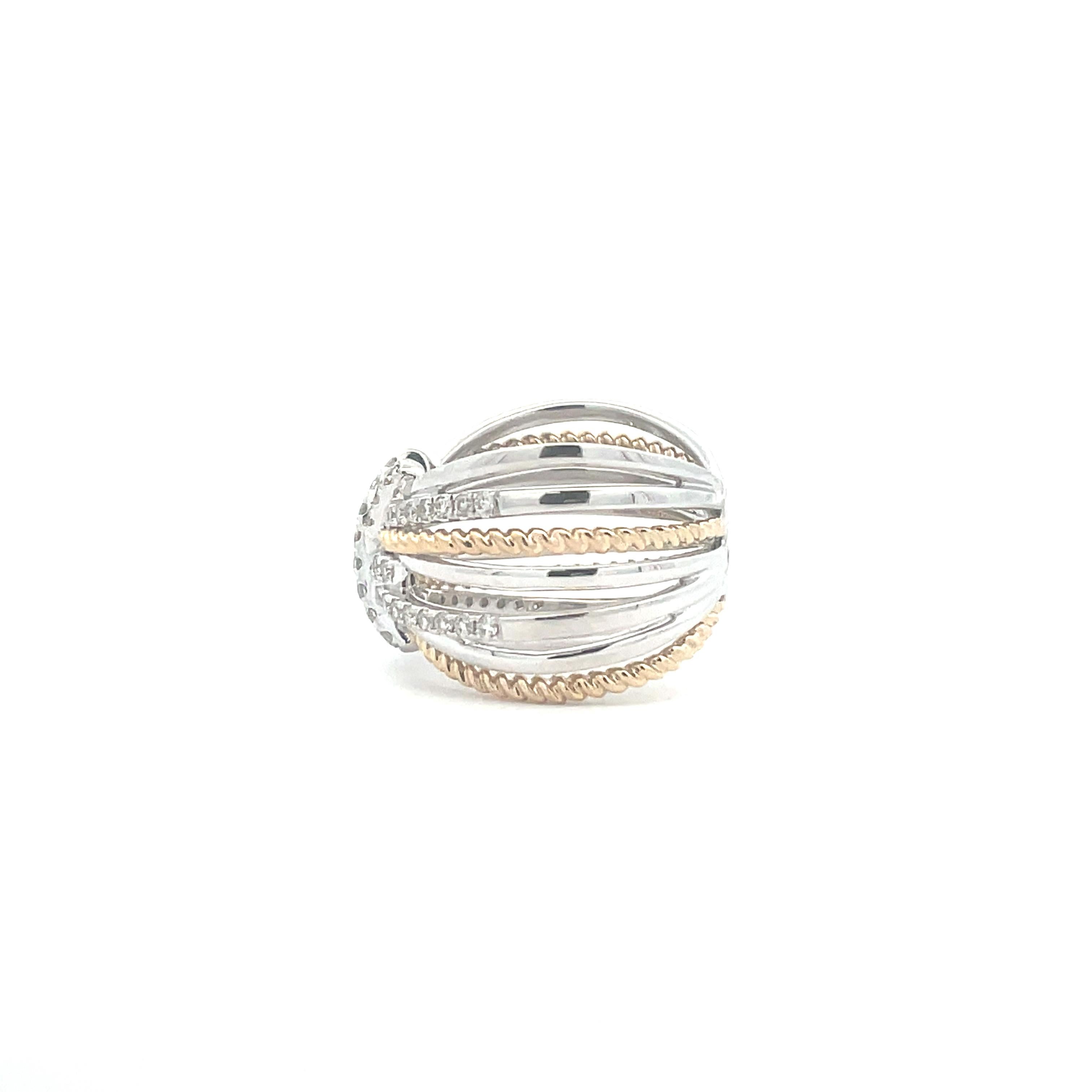 This ring is a true show stopper. This criss cross design features pave set diamonds in 14k white gold, set in the middle of a yellow gold highway band. Truly, a statement piece. Handcrafted by our artisans, this ring has been carefully crafted with