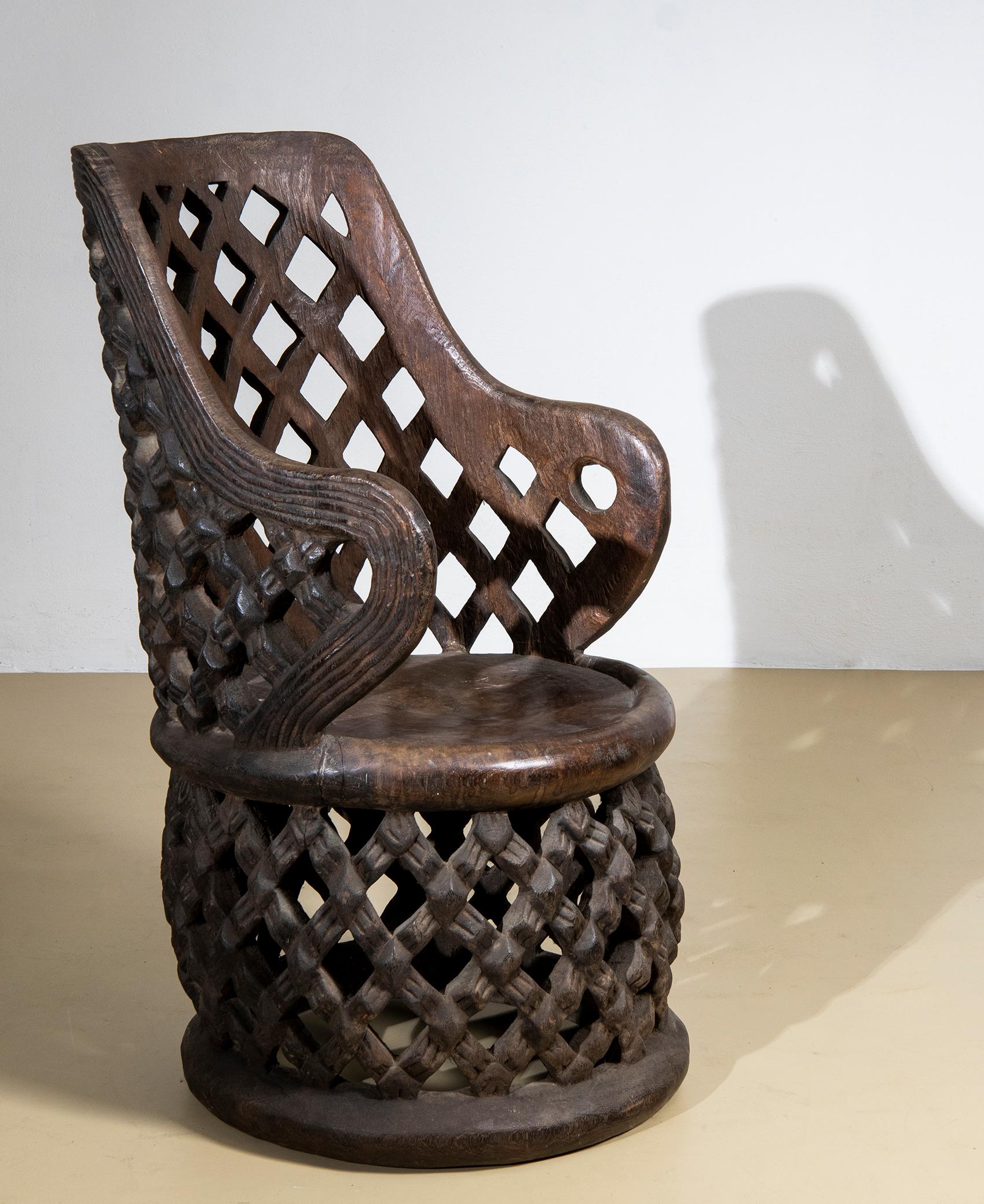 2 beautiful African thrones of the Bamileké people, Cameroon, hand-carved from a single log of Cola hardwood, stained black.
It features the typical Bamilekè perforated 'spider's web' workmanship, symbolizing the bond between the living and the