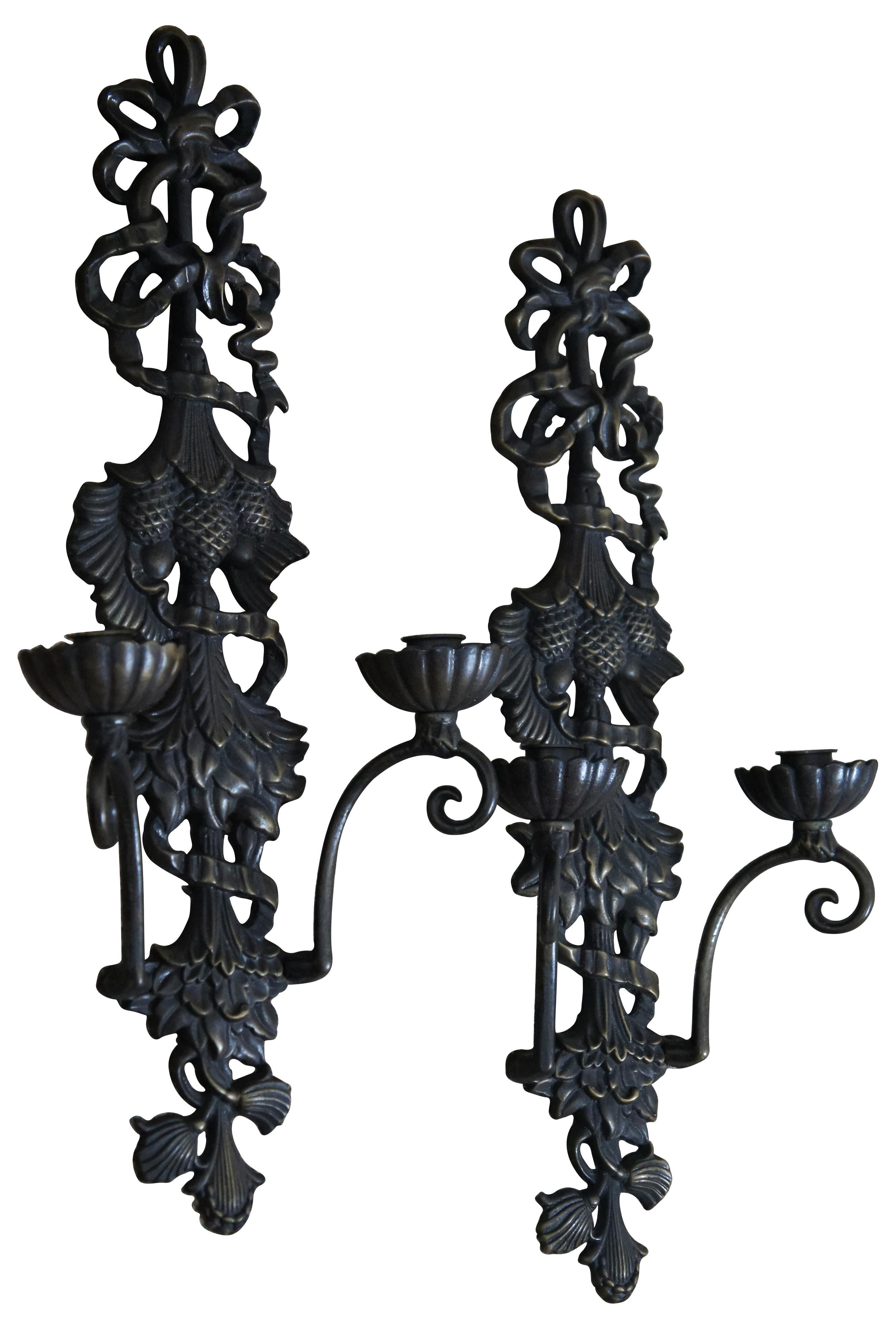 Pair of vintage bronze two light candle sconces featuring a Victorian design of ribbons, leaves and pine cones. Size: 21