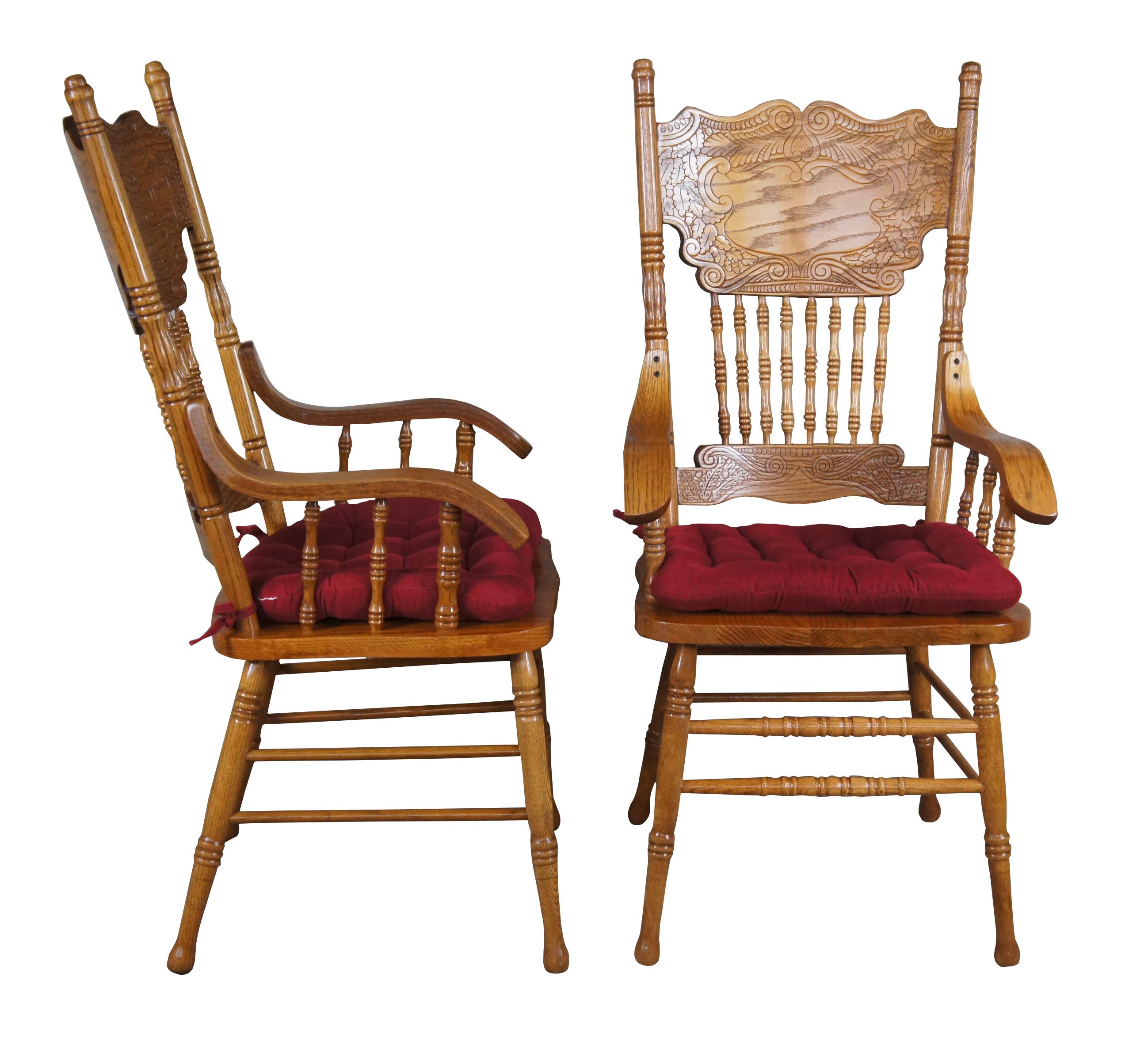 Late 20th century Victorian Revival arm chairs. Features a double pressback with spindled accents, sloped arms and a removable red upholstered seat.