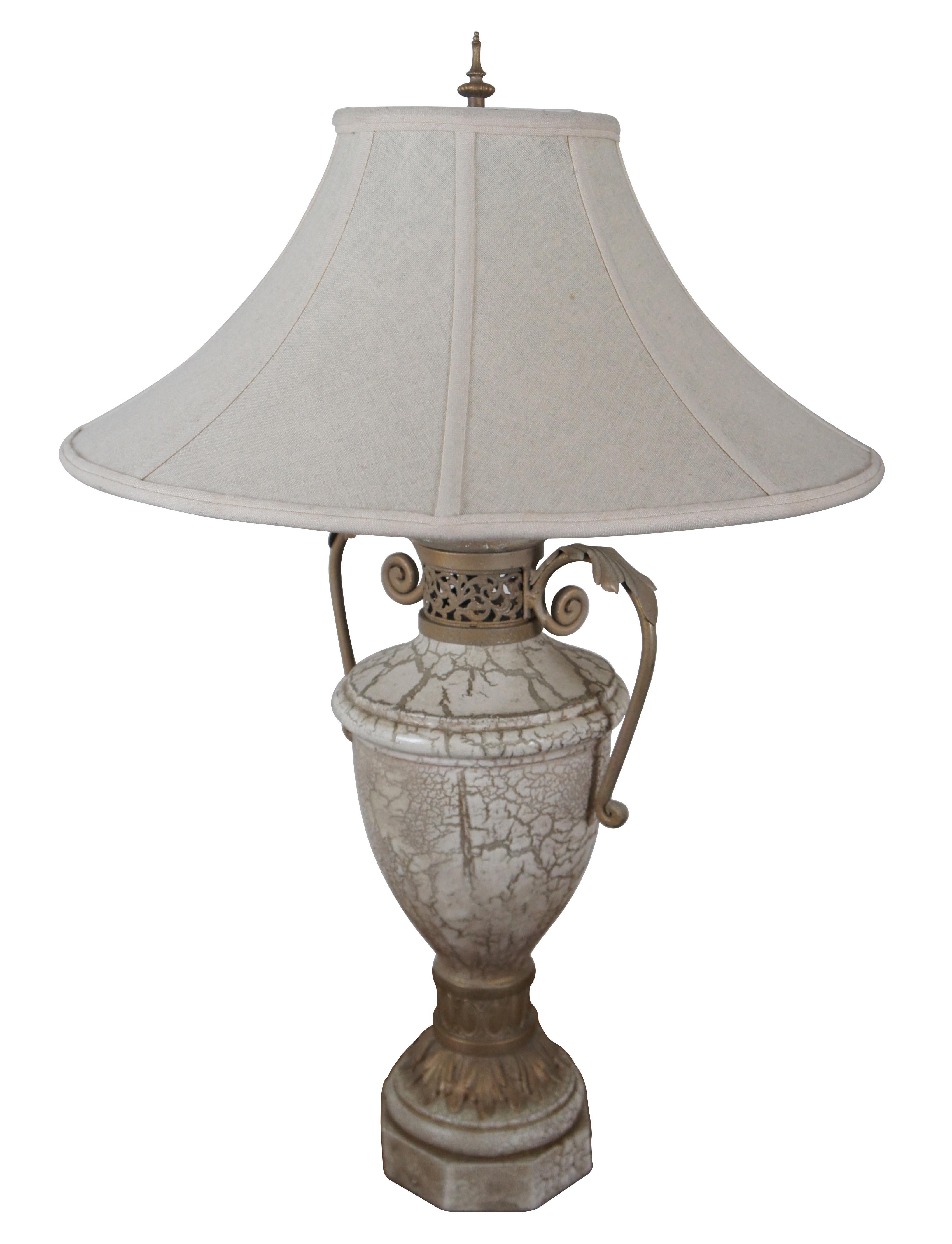 Pair of Neoclassical table lamps by the Ultimate Manufacturing Company, 1998. Trophy urn shaped in painted plaster with a white and gold marbled / crackle finish and painted metal collar and handles. White linen shades.


12.5” x 8.5” x 26” /