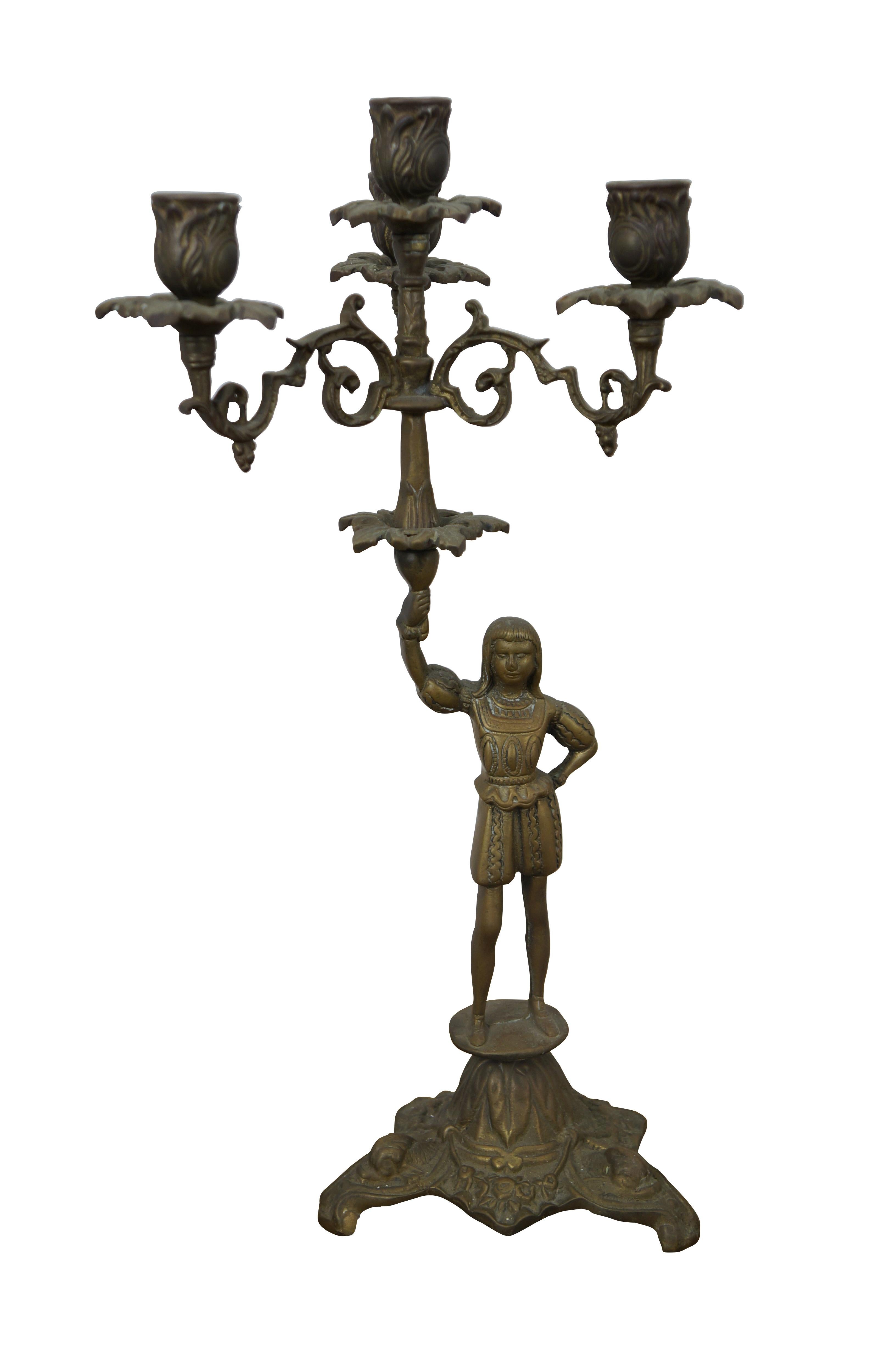 Due candelabri d'epoca in ottone con due figure in abiti rinascimentali che reggono una torchiera con quattro candelabri.  Supportato da una base a treppiede.

Dimensioni:
9