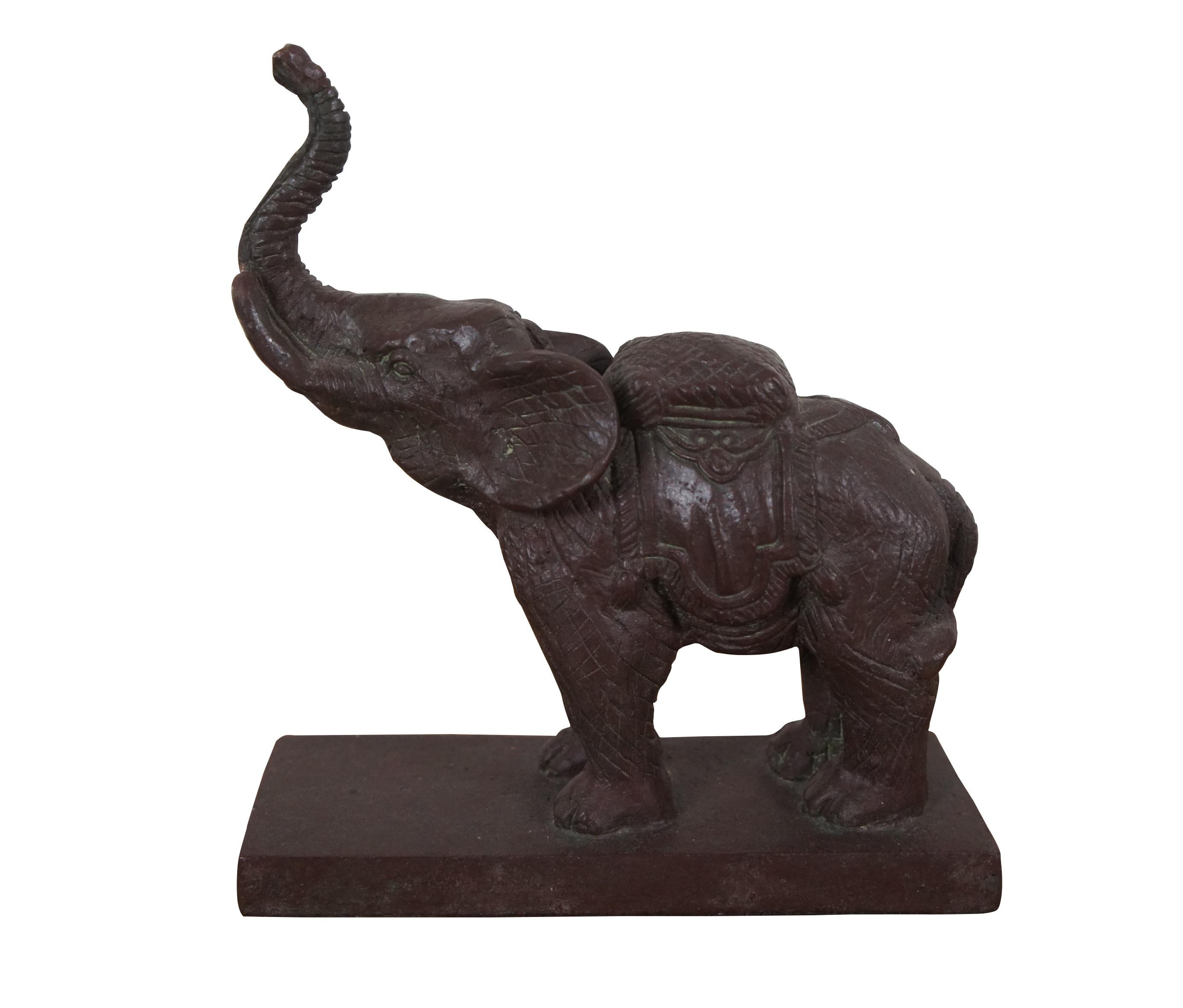Pair of cast bronze bookends in the shape of Asian / Indian elephants saddled with fringed rug and cushion, trunks raised in the air for luck, set on a simple rectangular base. Deep red / burgundy finish.

Dimensions:
6.5