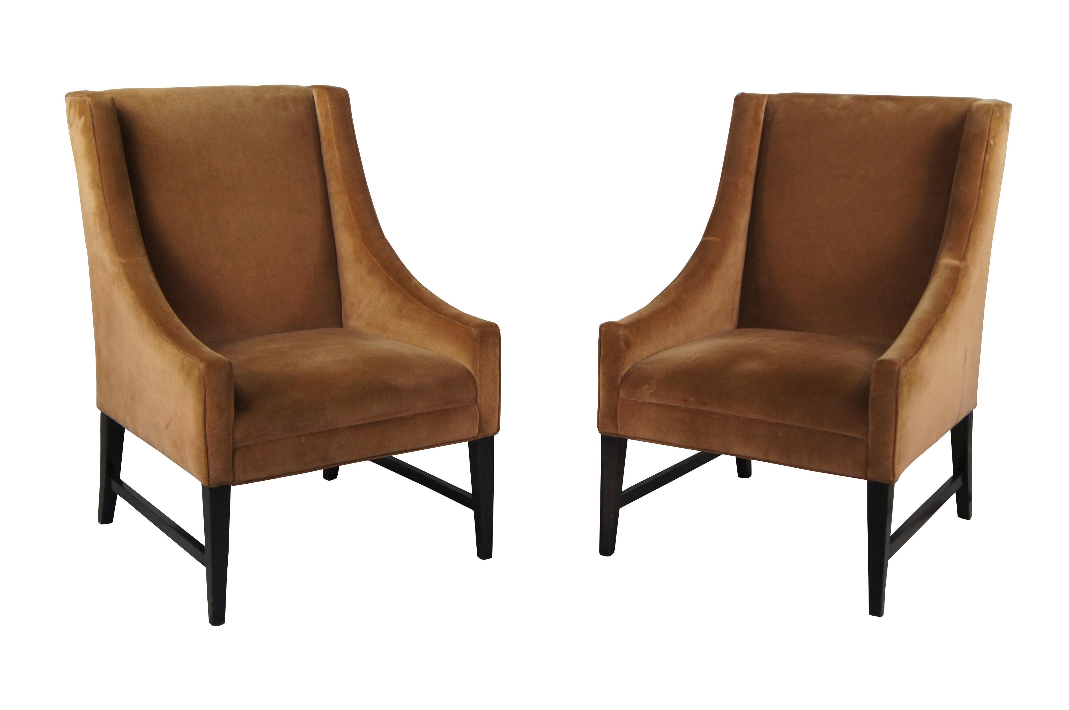 Pair of vintage brown velvet wingback style club chairs, featuring swooped arms over square tapered wooden legs.