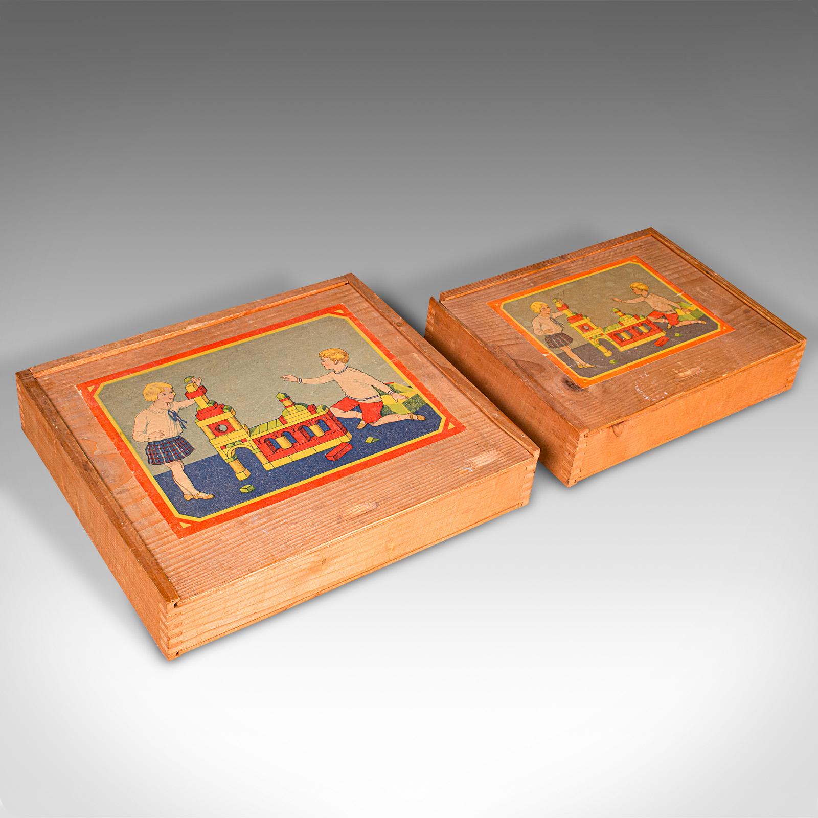 Dies ist ein Satz von zwei Vintage-Bausteinkästen. Ein deutscher Spielzeugkasten aus Kiefernholz in der Art von Froebel, aus der Mitte des 20. Jahrhunderts, um 1950.

Zwei faszinierende Baukastensets mit großem zeittypischen Reiz
Selten und
