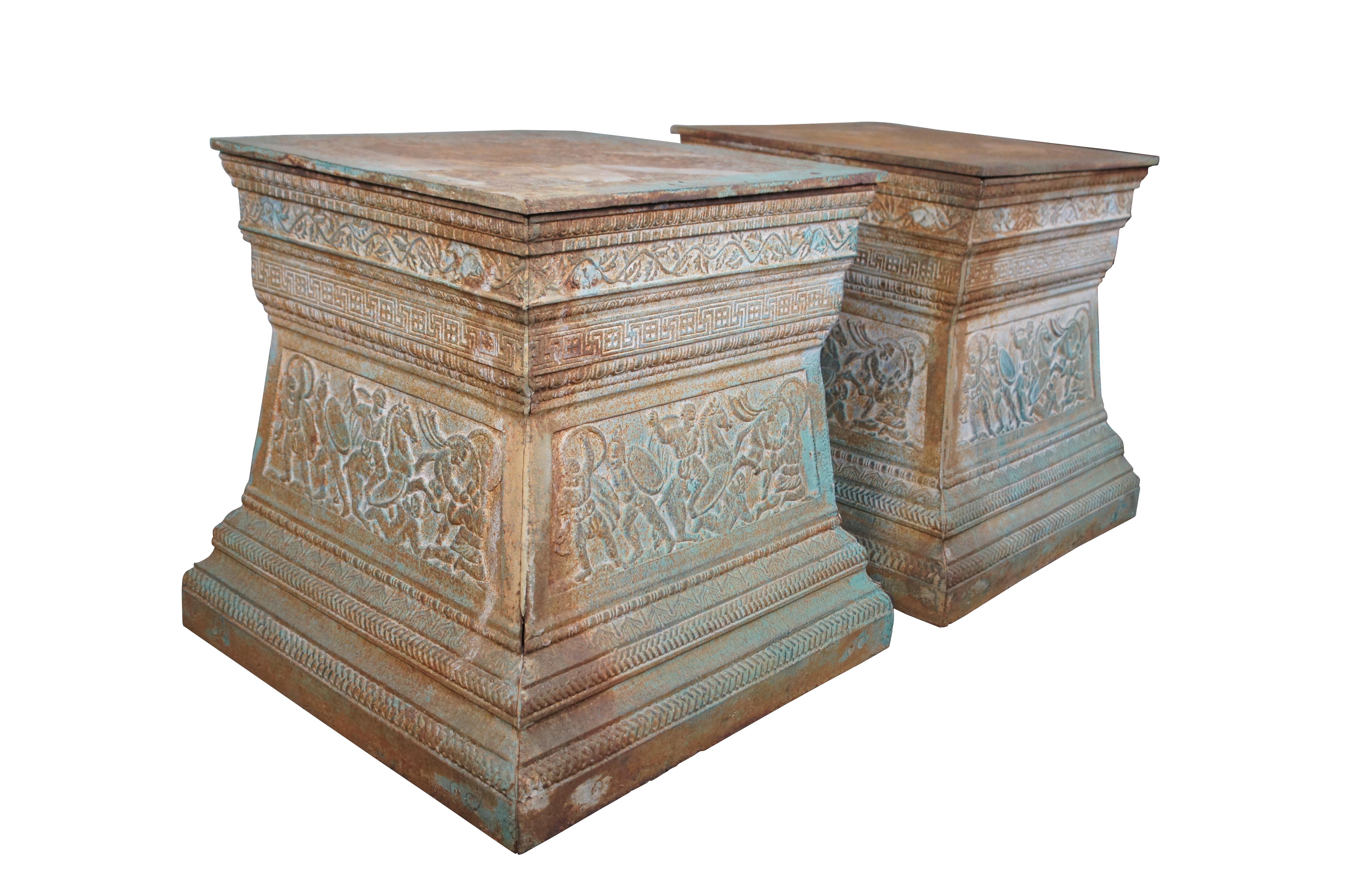 Grande paire de socles grecs en fonte.  Elle présente une forme carrée et effilée avec des scènes d'hommes et de chevaux.   Le piédestal est orné d'un gel feuillu, d'une garniture à chevrons et de moulures sculptées.  Parfait pour présenter une urne