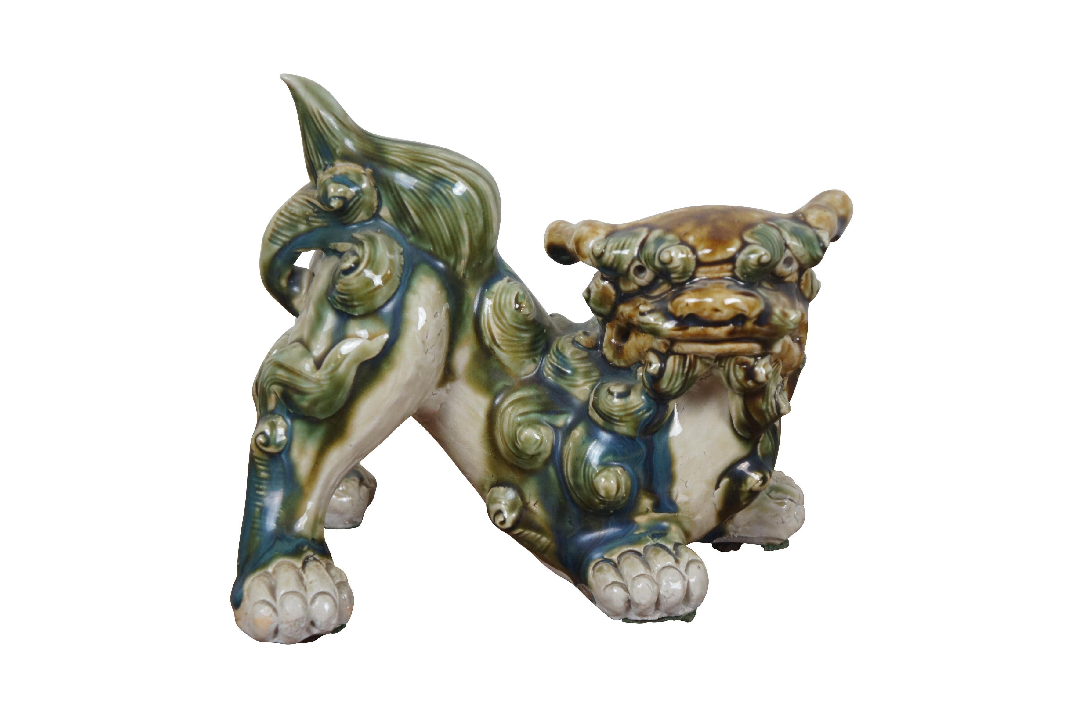 Pair of 20th century shishi / guardian lion / foo dog figurines. Ceramic glazed in green, teal and brown. Incised with Okinawa on rear leg.

