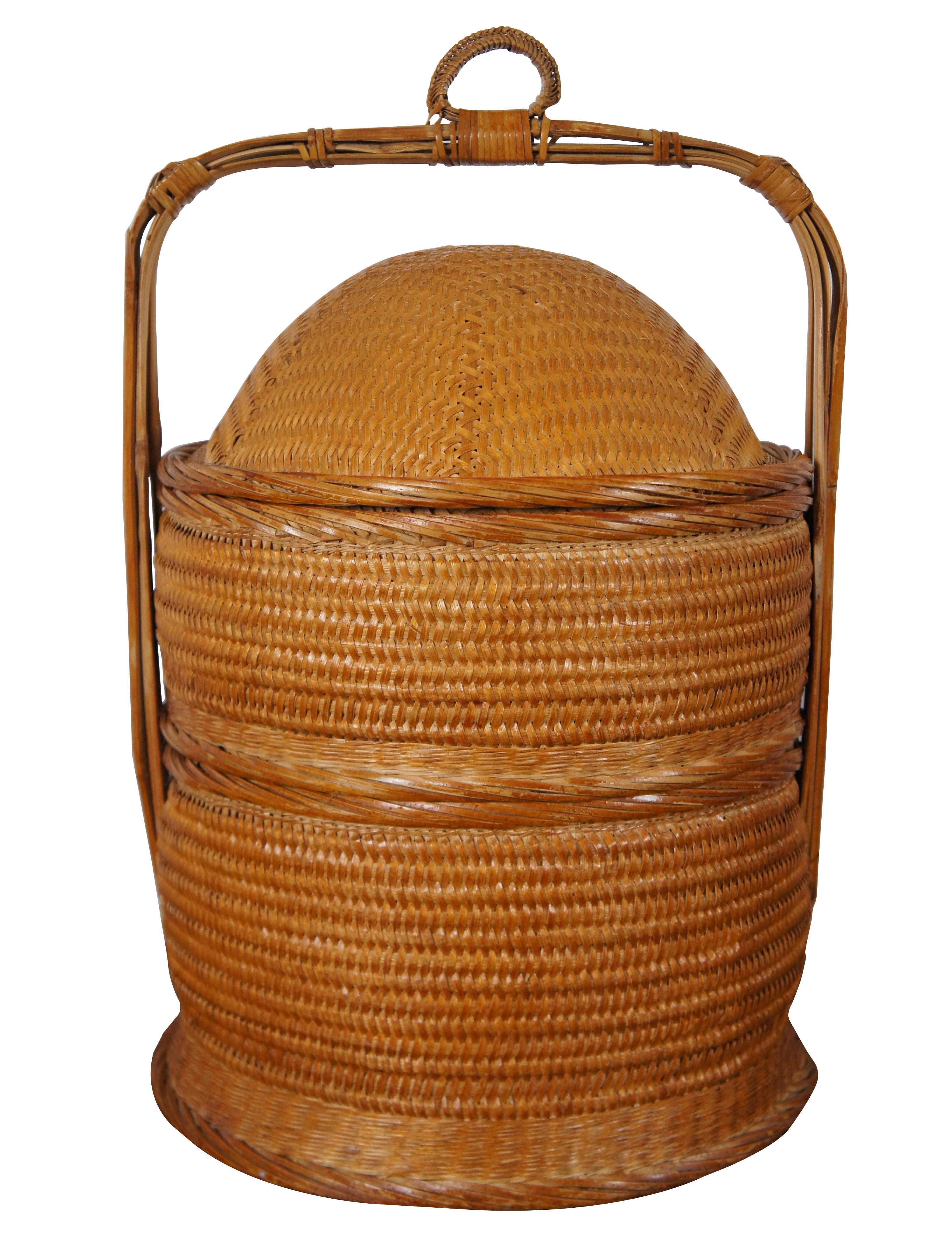 Pair of vintage 20th century bentwood bamboo / rattan / wicker Chinese wedding baskets, both featuring round bodies, domed lids and squared off, fixed handles at the top. The smaller is single tiered and the larger is two tiered.

Measures: taller