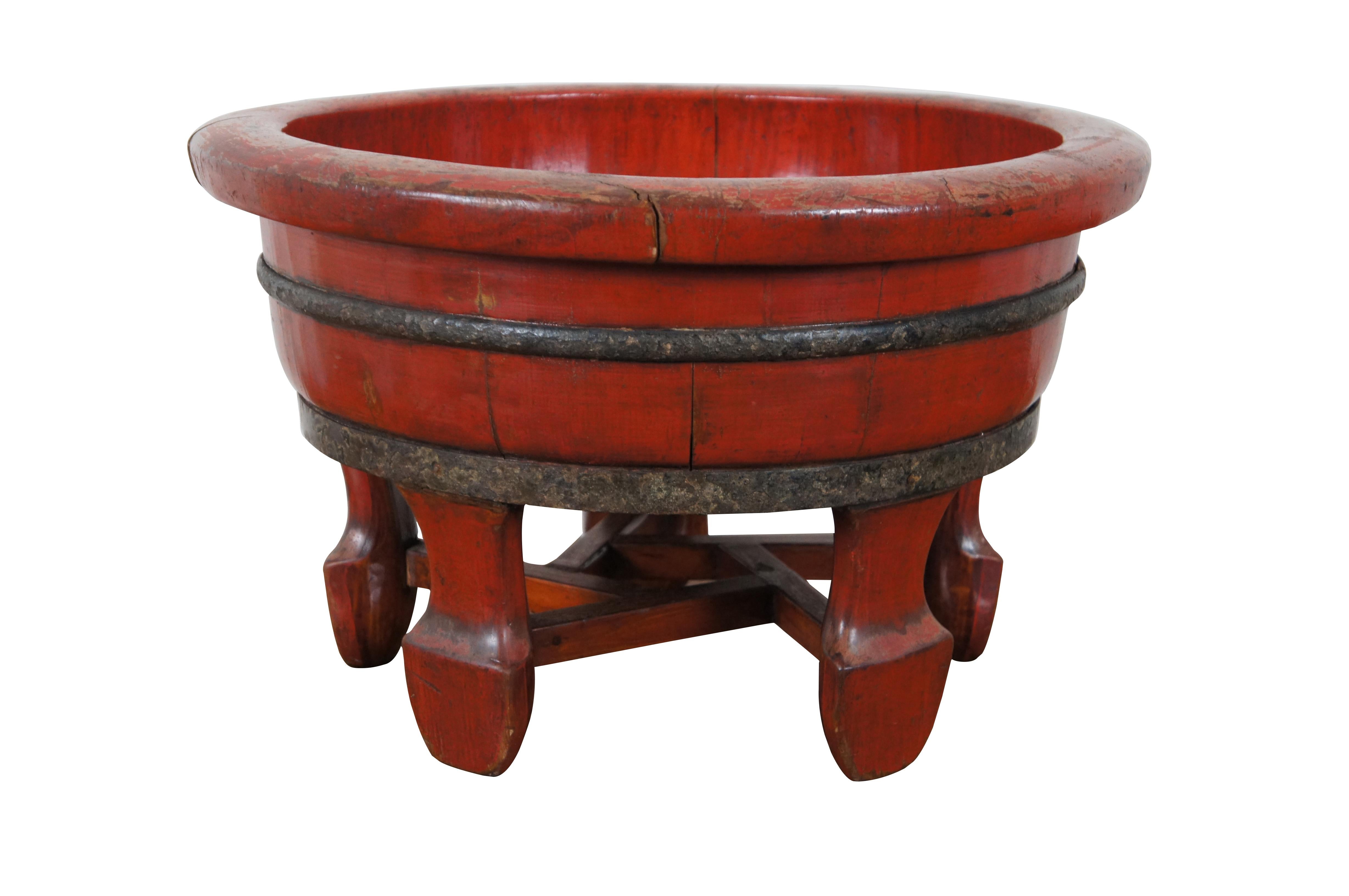 Pair of antique half-barrel shaped wooden wash / baby basins, finished in red lacquer with iron bands and five legs reinforced with pentagonal stretchers. Sticker on bases from previous re-seller.

In the pre-industrial world, the wash basin was a