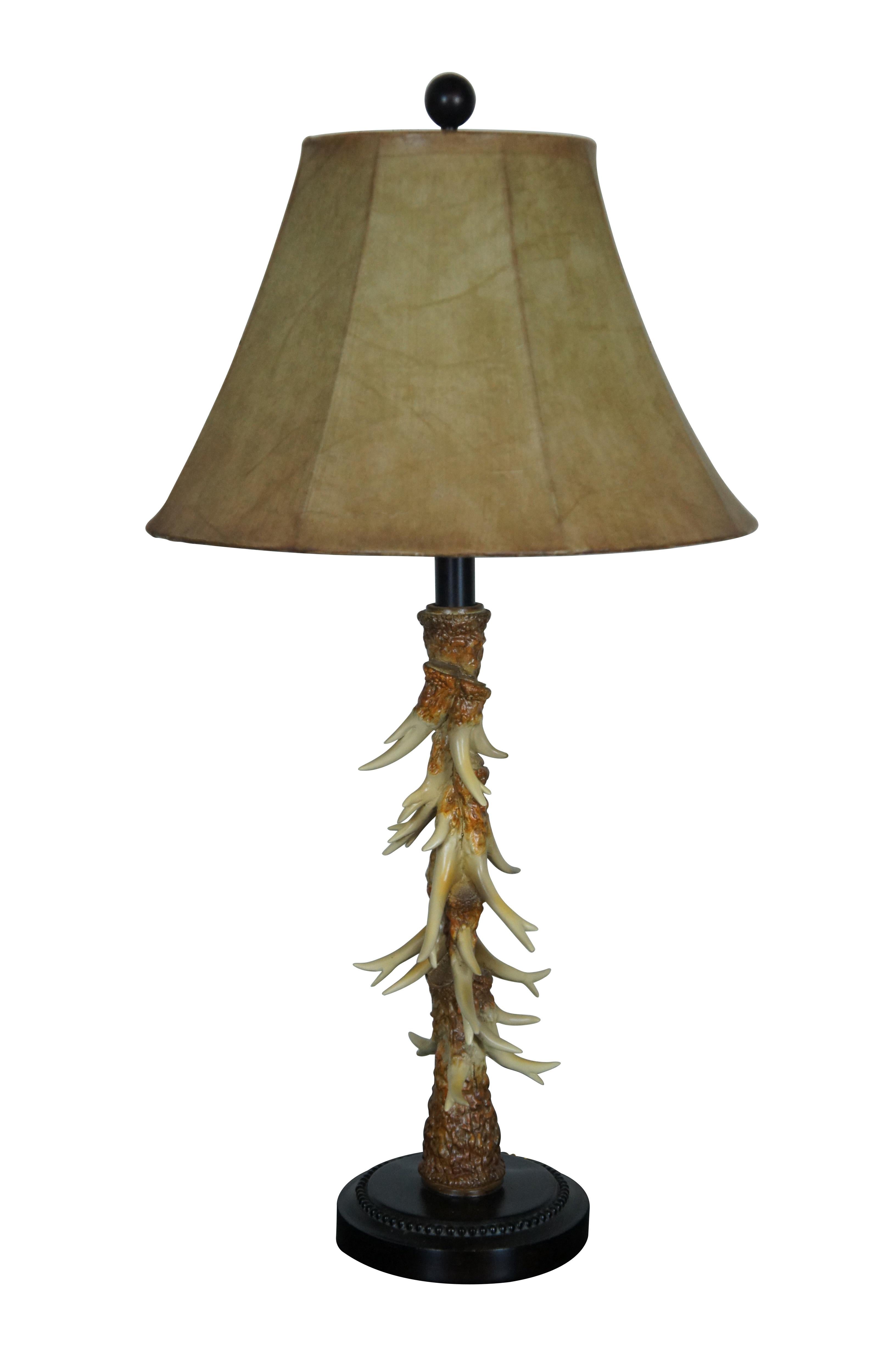 Two vintage hunting / cabin theme table lamps. Made of resin featuring faux antler body with hide style shades and turned wood base.

6.5” x 21” / Shade - 15” x 9” / Total Height – 29” (Width x Depth x Height)
