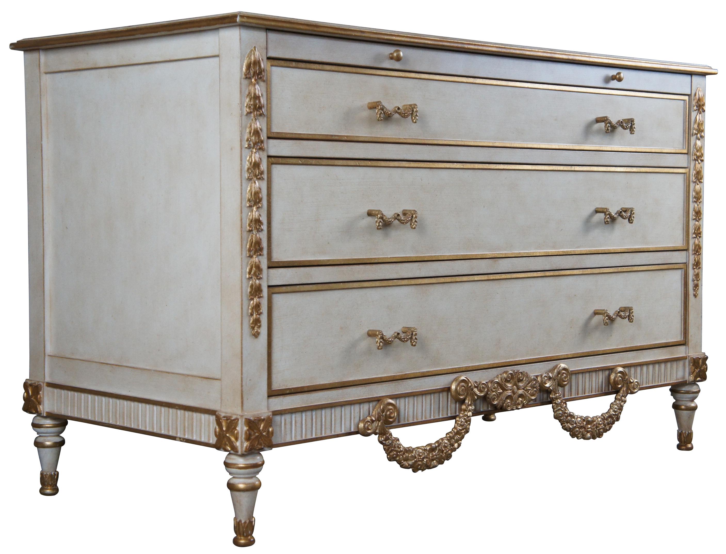 Stunning pair of late 20th century chest of drawers. Attributed to Auffray & Co. Features a blend of Louis XVI and Rococo styling. Finished in white with gold trim. Includes three dovetailed drawers and a large pull-out surface. 

Provenance :