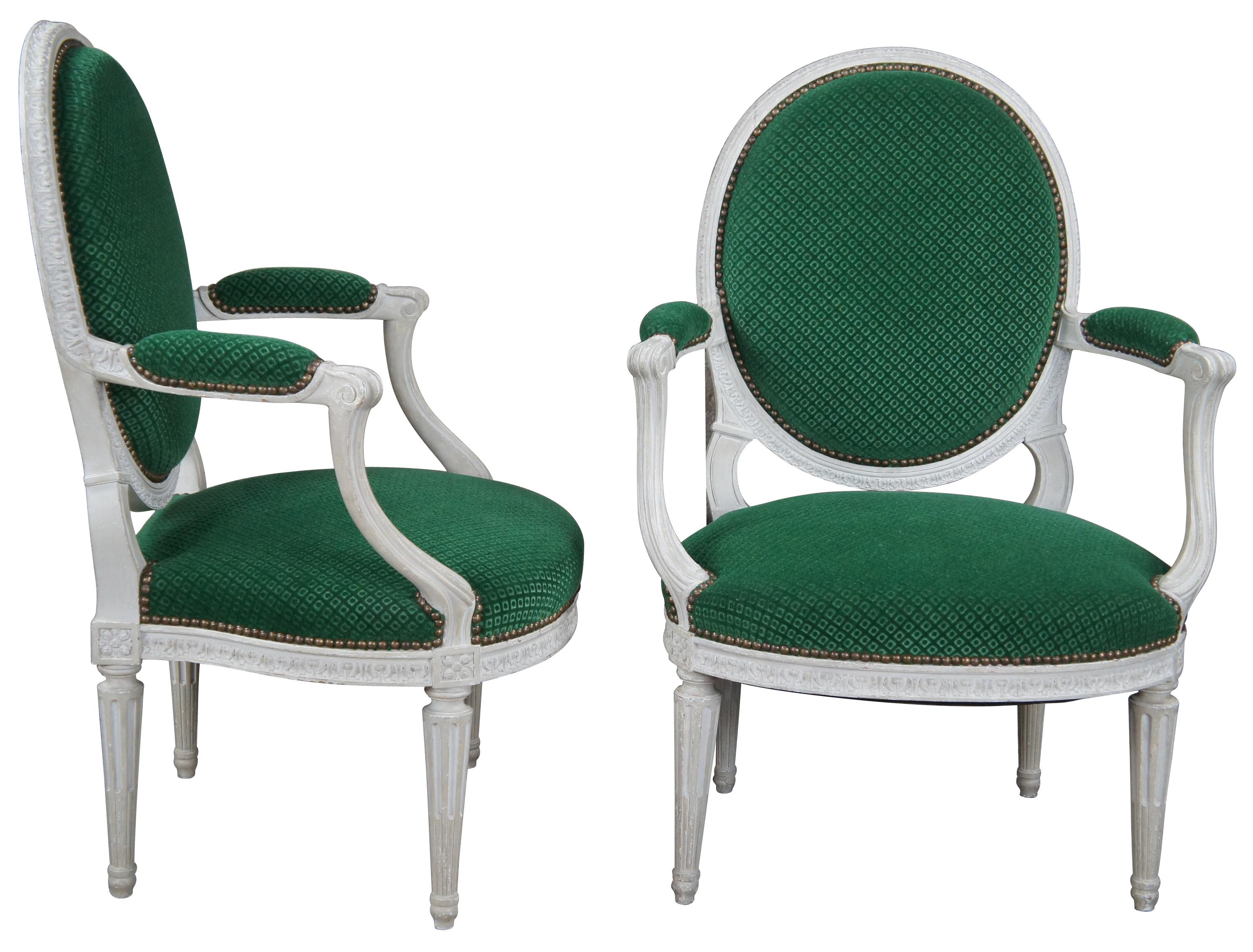 An elegant pair of English George III style open arm chair, circa 1960s. Features a balloon back, scrolled padded arms and tapered fluted legs. The chairs are trimmed with acanthus moldings, upholstered in a green diamond fabric and finished with