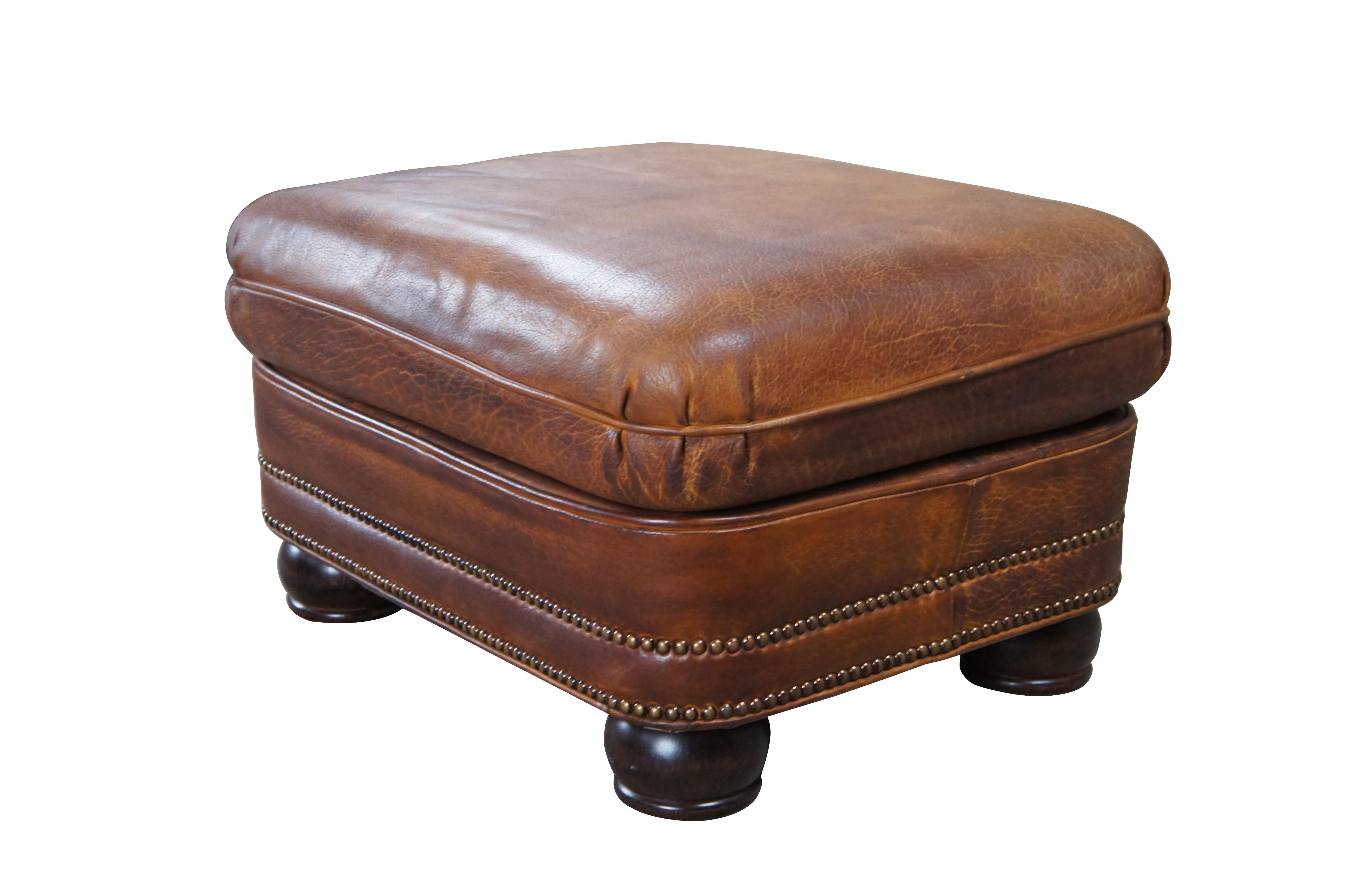 Beautiful pair of Hancock & Moore Austin Traditional Ottomans. Upholstered a rich top grain brown leather with brass nailhead trim. The rectangular form features a cushioned top and robust bun feet.

Dimensions:
23