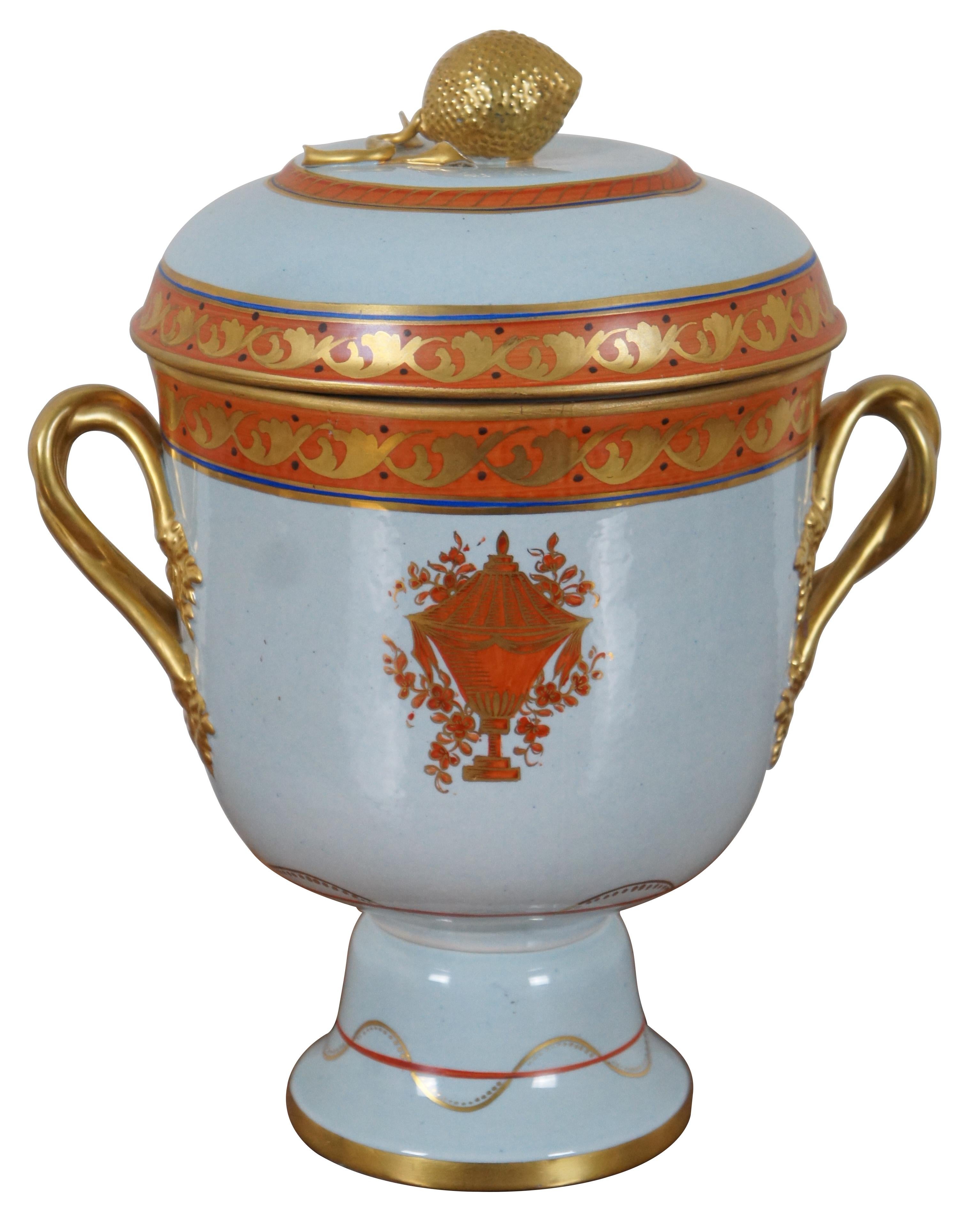 Pair of vintage mid 20th century reproduction Lowestoft style porcelain by Mottahedeh, one lidded cachepot and one tea pot, featuring a lightly blue tinted base, decorated with vase, foliate, and floral designs in orange, blue and gold, with fruit