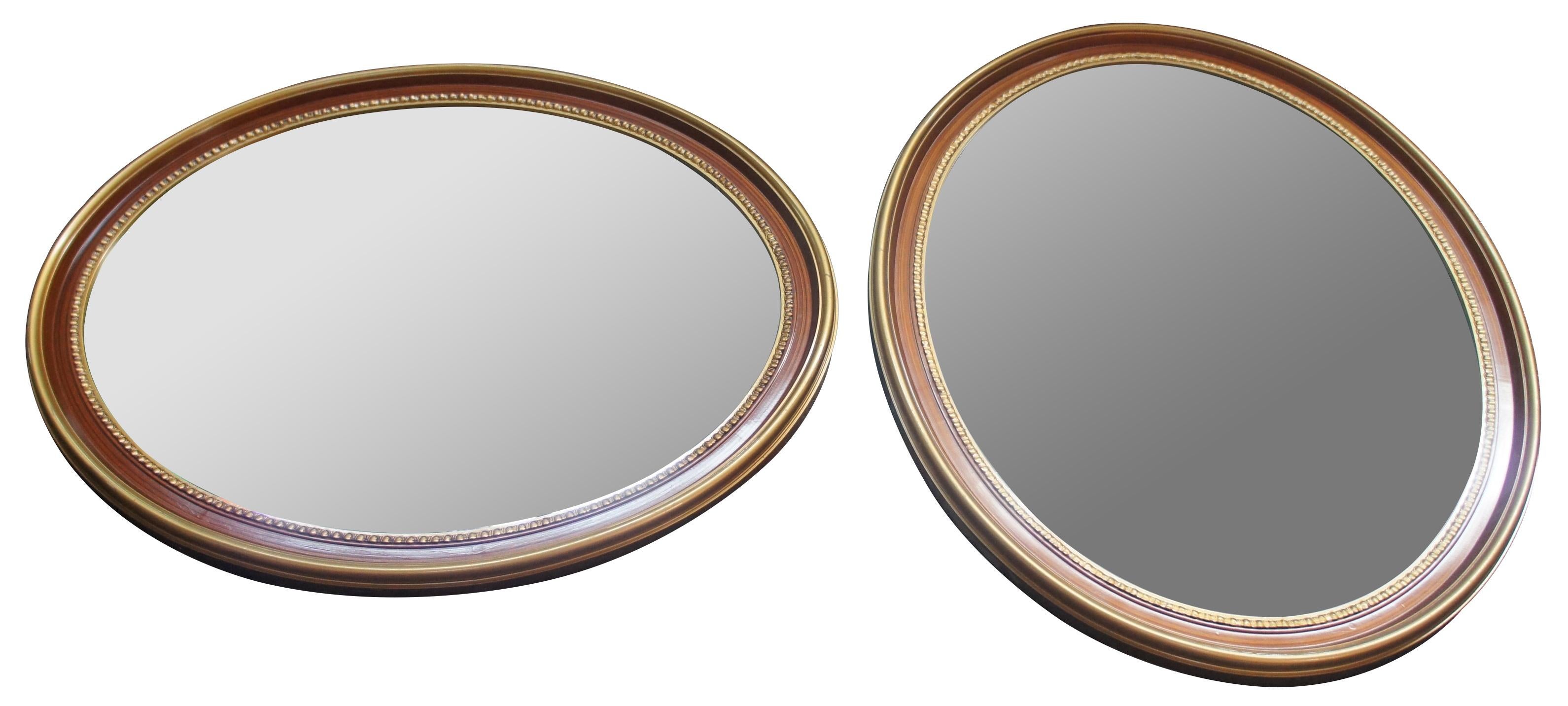 2 vintage oval wall or vanity mirrors featuring a painted grain with gold gilded and beaded accents.