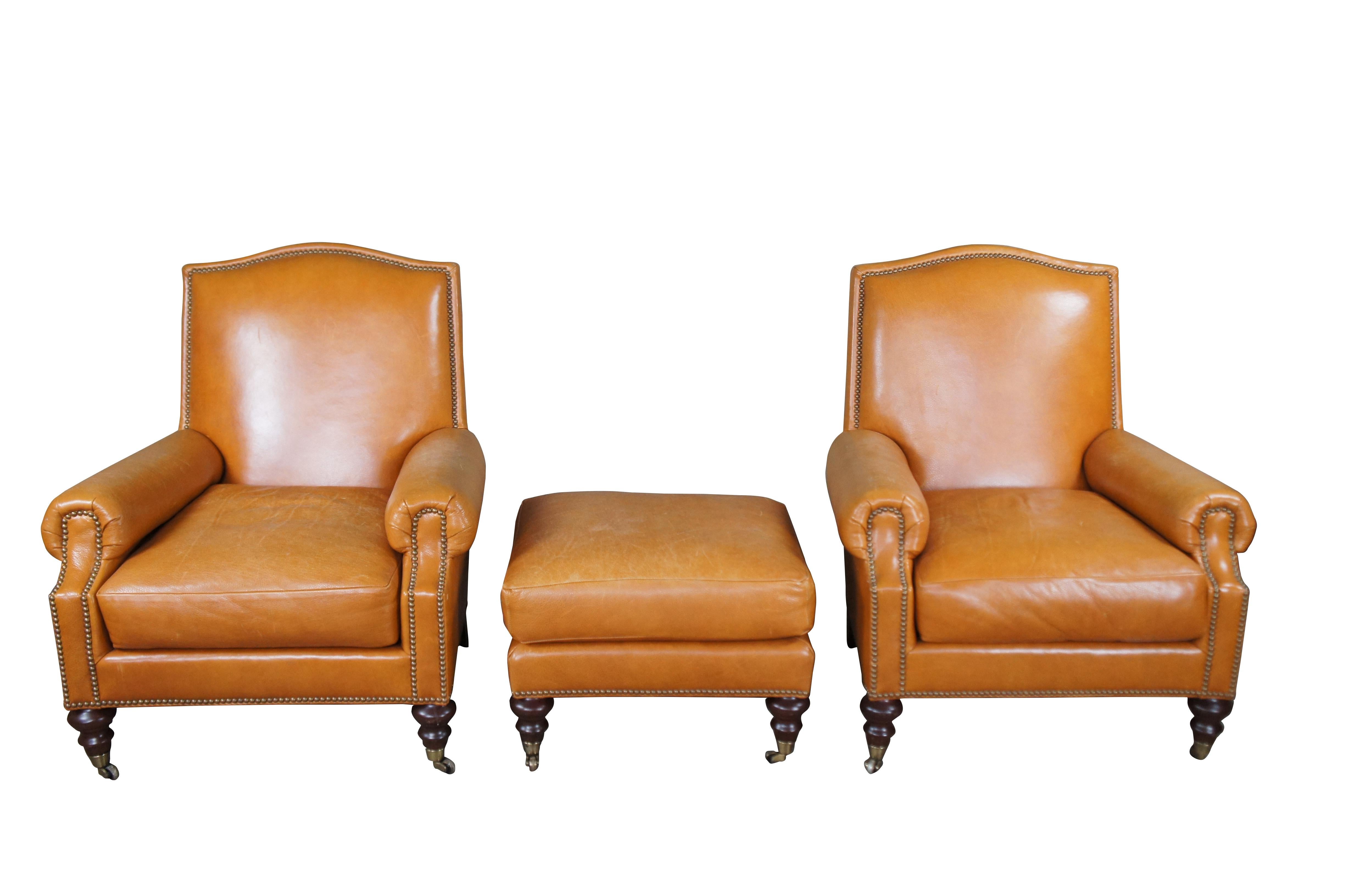 A charming pair of Pearson leather armchairs and ottoman.  Features an orange upholstery with thick arms and brass nailhead trim.  The chairs are supported by turned legs with brass capped casters.

Dimensions:
36