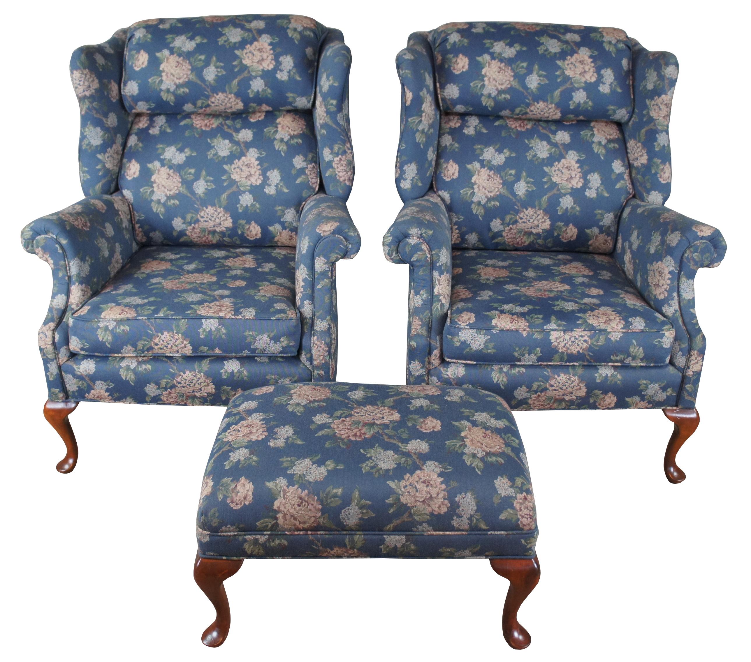 Vintage set of two wingback chairs and ottoman. Made of mahogany featuring a blue floral fabric with rolled arms, padded headdress and Queen Anne slipper feet. Custom upholstered by Shelby Upholstering & Interiors of Indianapolis.

Measures:
