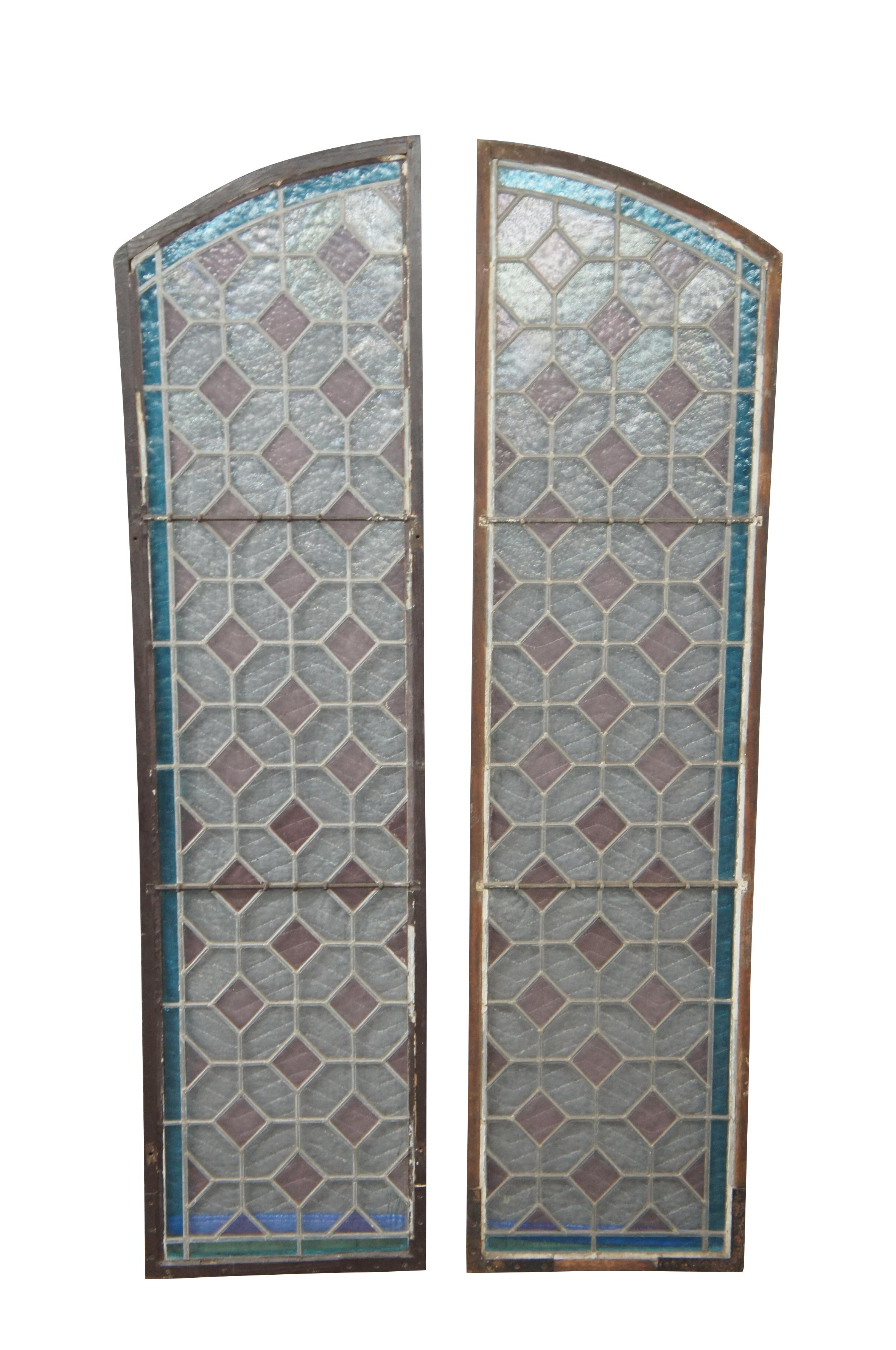 An exceptional pair of diamond pattern stained glass windows.  Features an arched form with geometric leaded dimaond pattern.  The windows are framed in blue with a ruby diamond pattern.  

Dimensions:
15.25
