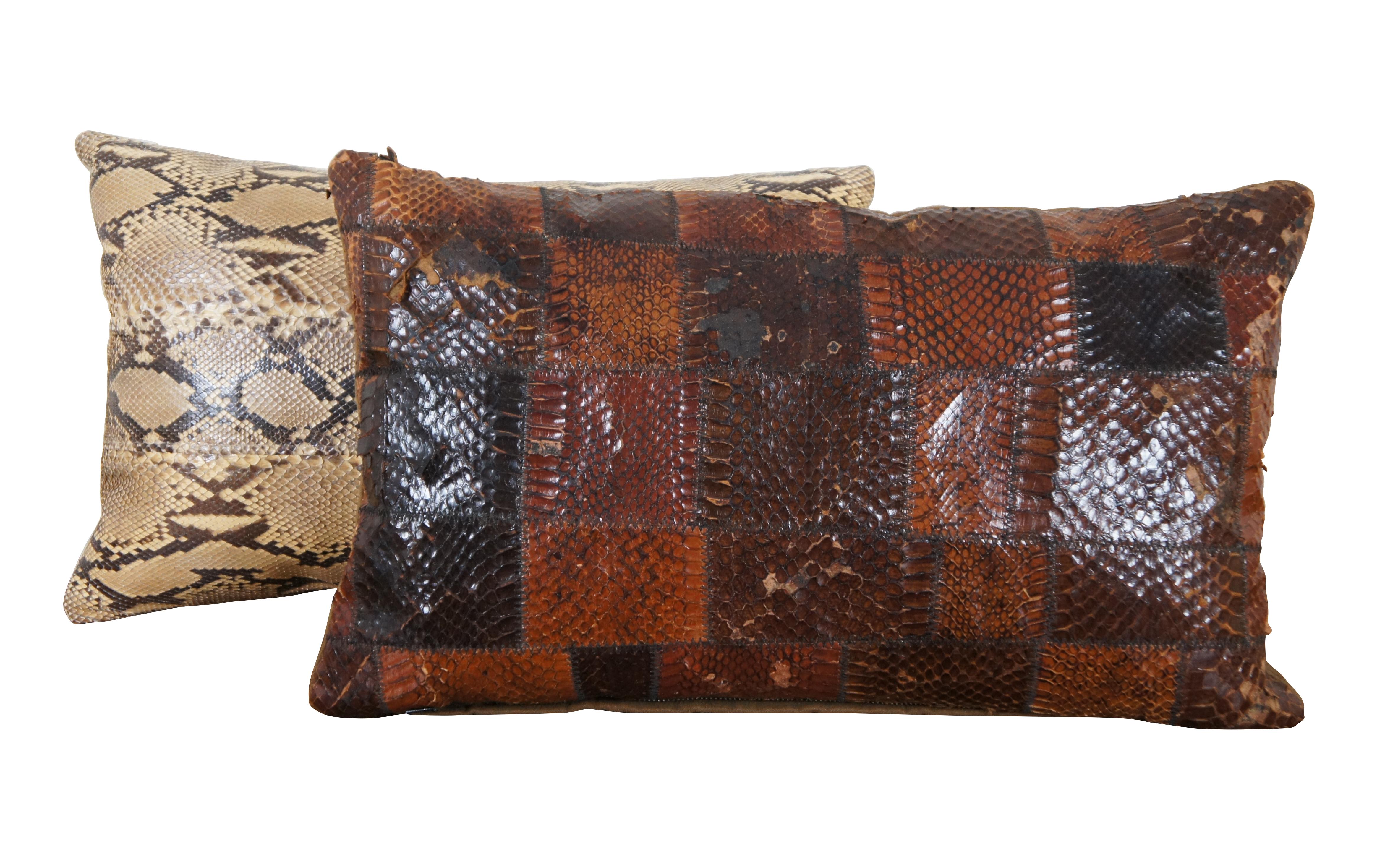 Pair of vintage polyester fiber filled, real snakeskin lumbar throw pillows, one black and cream with off-white leather back, the other a checkered patchwork piece in shades of brown with a brown fleece back.

Brown - 17” x 4” x 10” / Cream - 15”