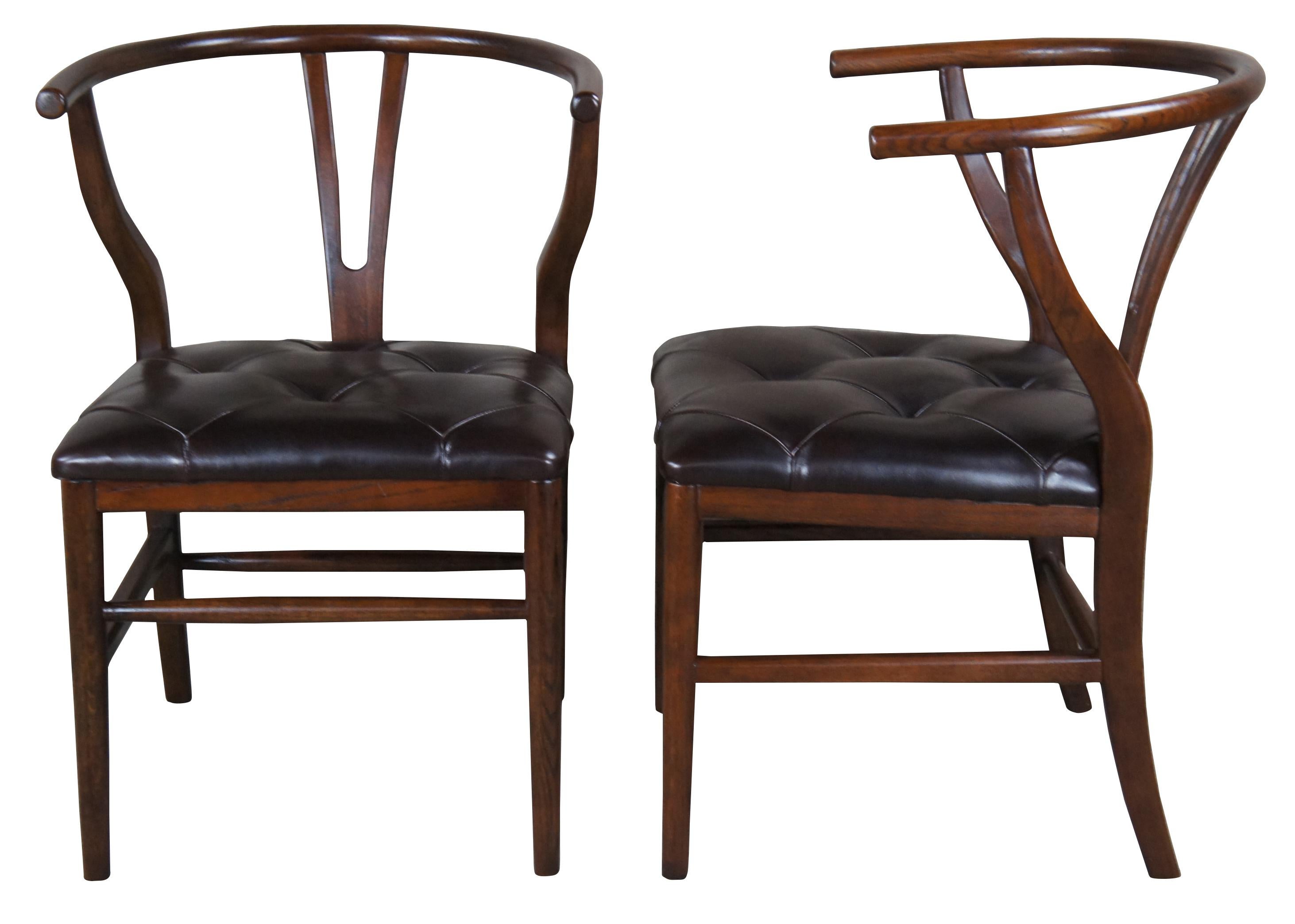 Two vintage walnut horseshoe armchairs featuring tufted leather seat and tapered legs. These chairs were made after the iconic mid century modern wishbone design of Hans Wegner.

Measures: 22