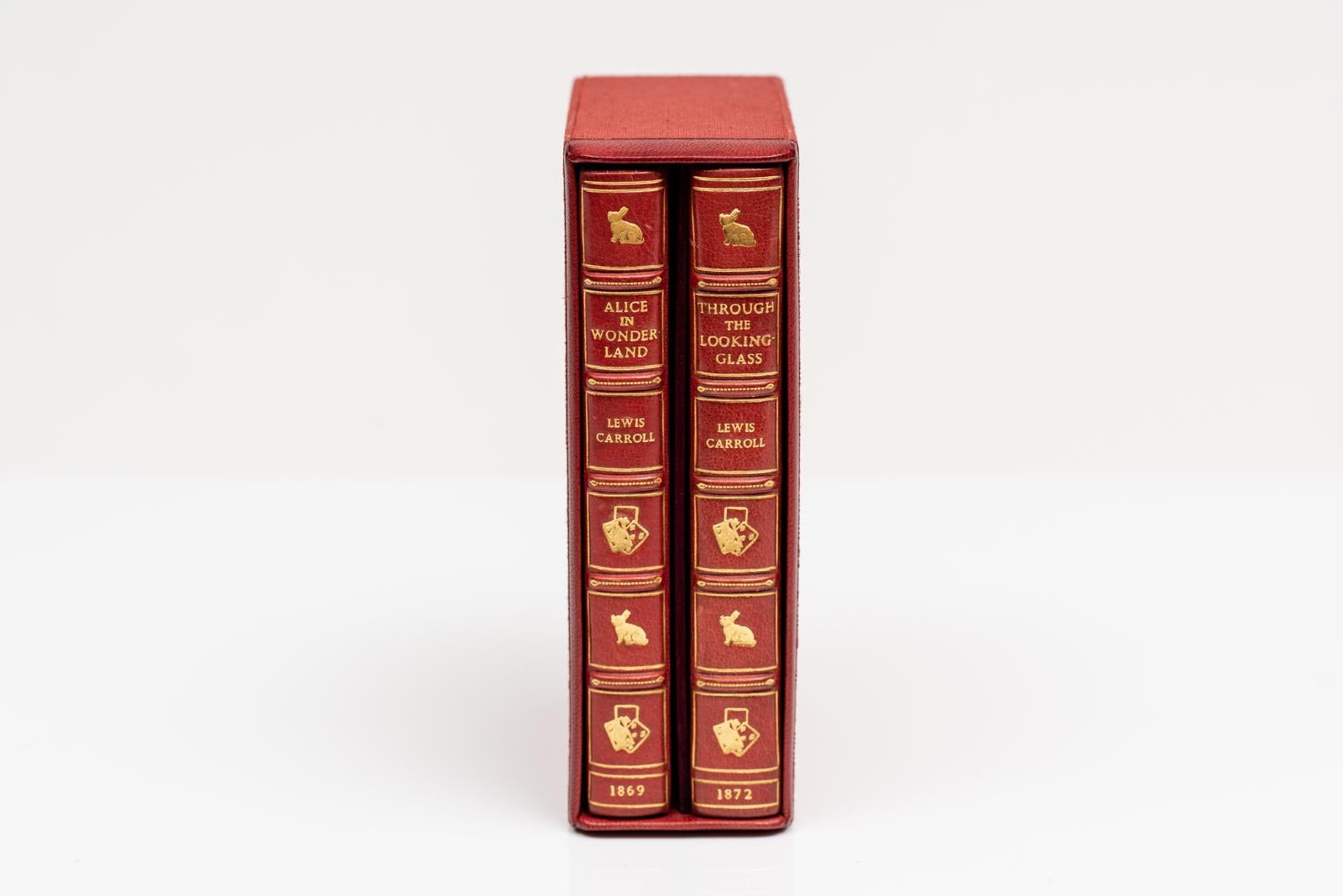2 volumi. Lewis Carroll, Alice nel paese delle meraviglie e Attraverso lo specchio. Rilegato in pieno marocchino rosso da Bayntun. Tutti i bordi sono dorati. Coniglio e regina dorati sulle copertine anteriori, con doratura sui dorsi a bande in
