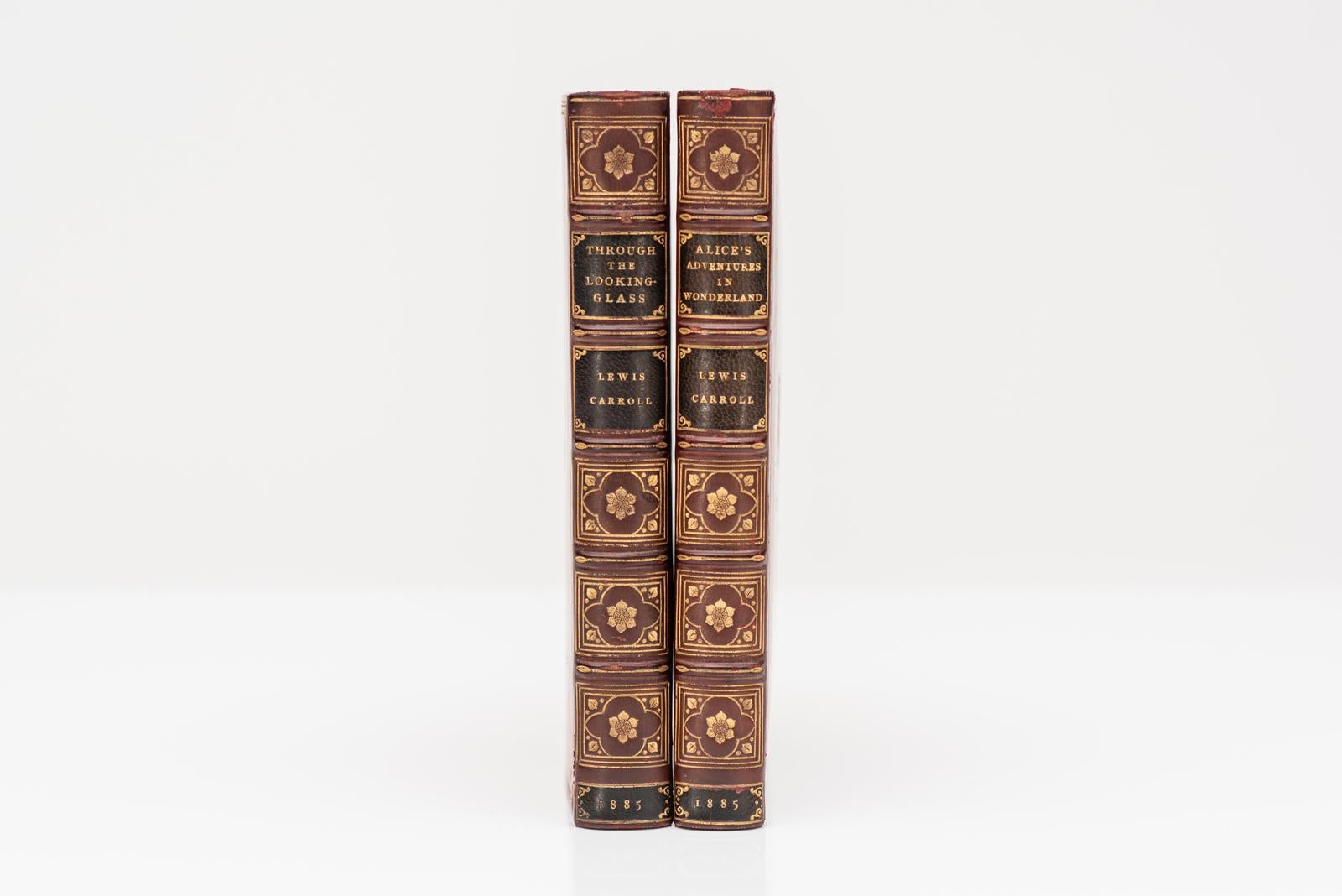 2 Volumes. Lewis Carroll. Alice au pays des merveilles et De l'autre côté du miroir. Illustré par John Tenniel. Première édition. Reliure en plein veau rouge par Tout, toutes les tranches dorées, bandes surélevées, panneaux dorés, couvertures