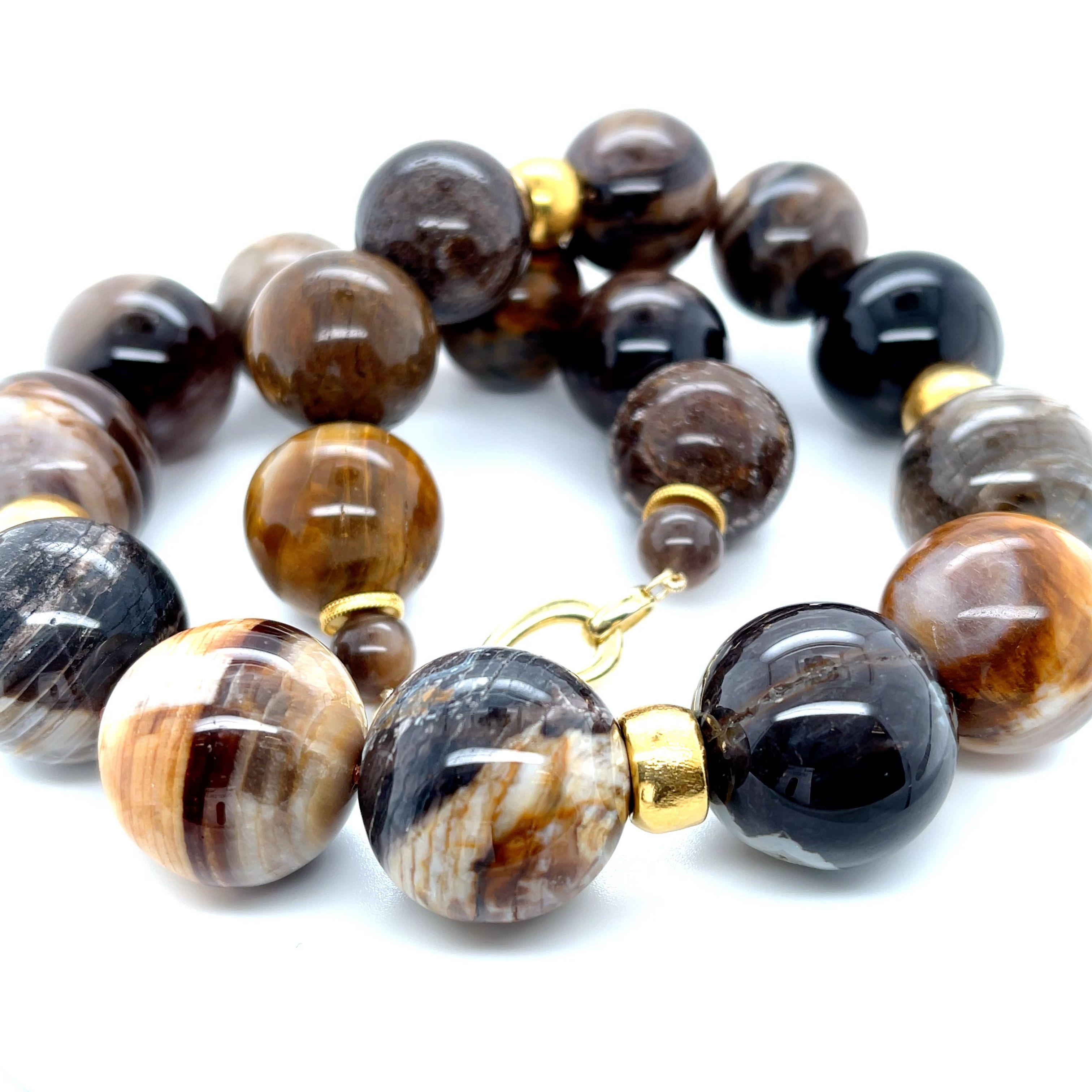 This impressive necklace has a wonderfully organic feel and features a stunning collection of unusually large wood opalite beads accented with large 18k yellow gold rondels. Wood opalite forms when a material such as silica from volcanic ash settles