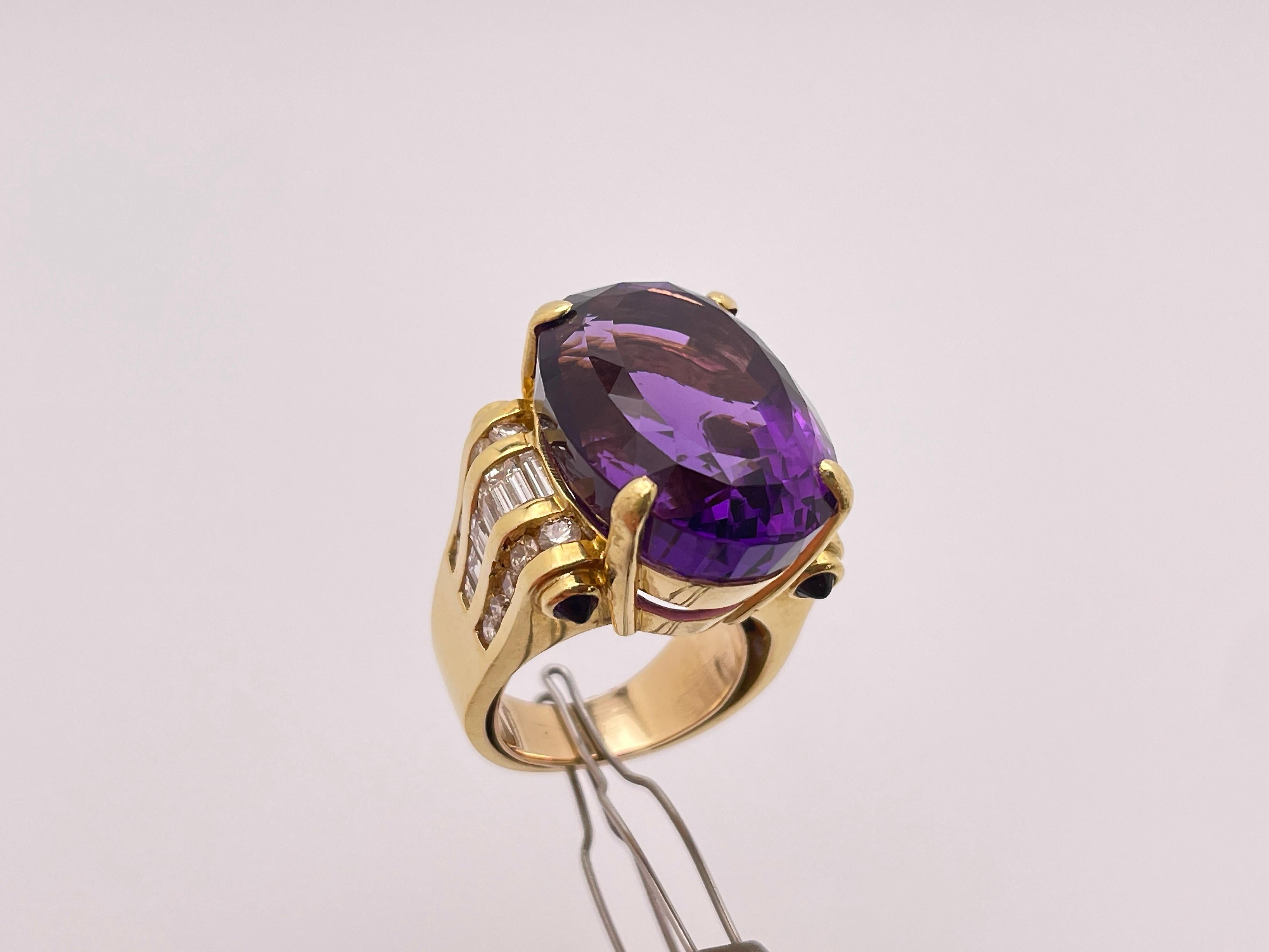 An 18 K (Karats) yellow gold amethyst diamond ring. Centered with one incredible oval-shaped genuine amethyst, measuring 22 x 16 mm and weighing approximately 20 CT (Carrots). Accompanied with 12 baguette cut diamonds weighing a total of