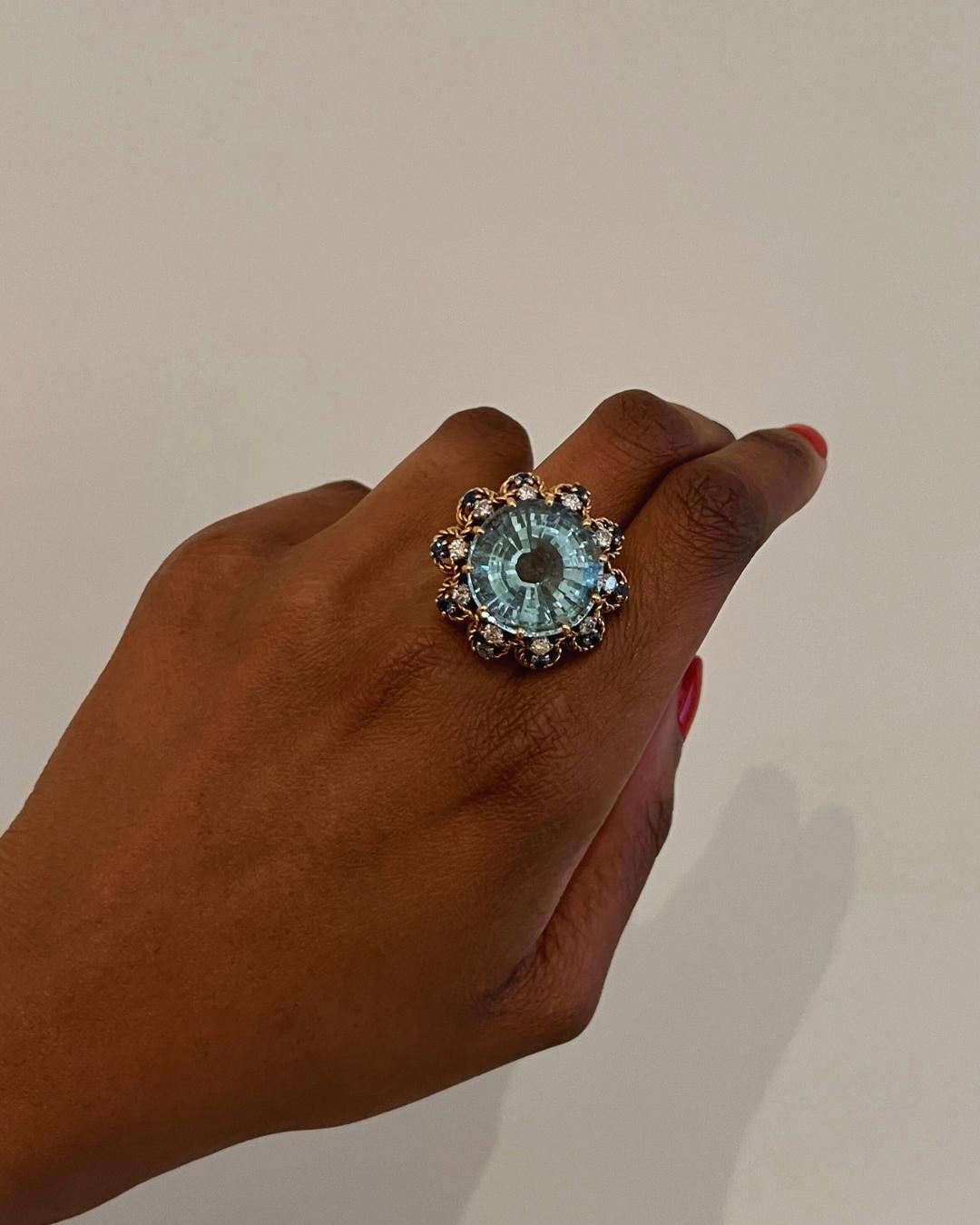 A 20-carat round-cut aquamarine surrounded by brilliant-cut diamonds and sapphires, ornamented with twisted gold wire, all an 18-karat rose gold set ring.  

The 1950s had something to say about jewelry, don’t you think? It was the beginning of the