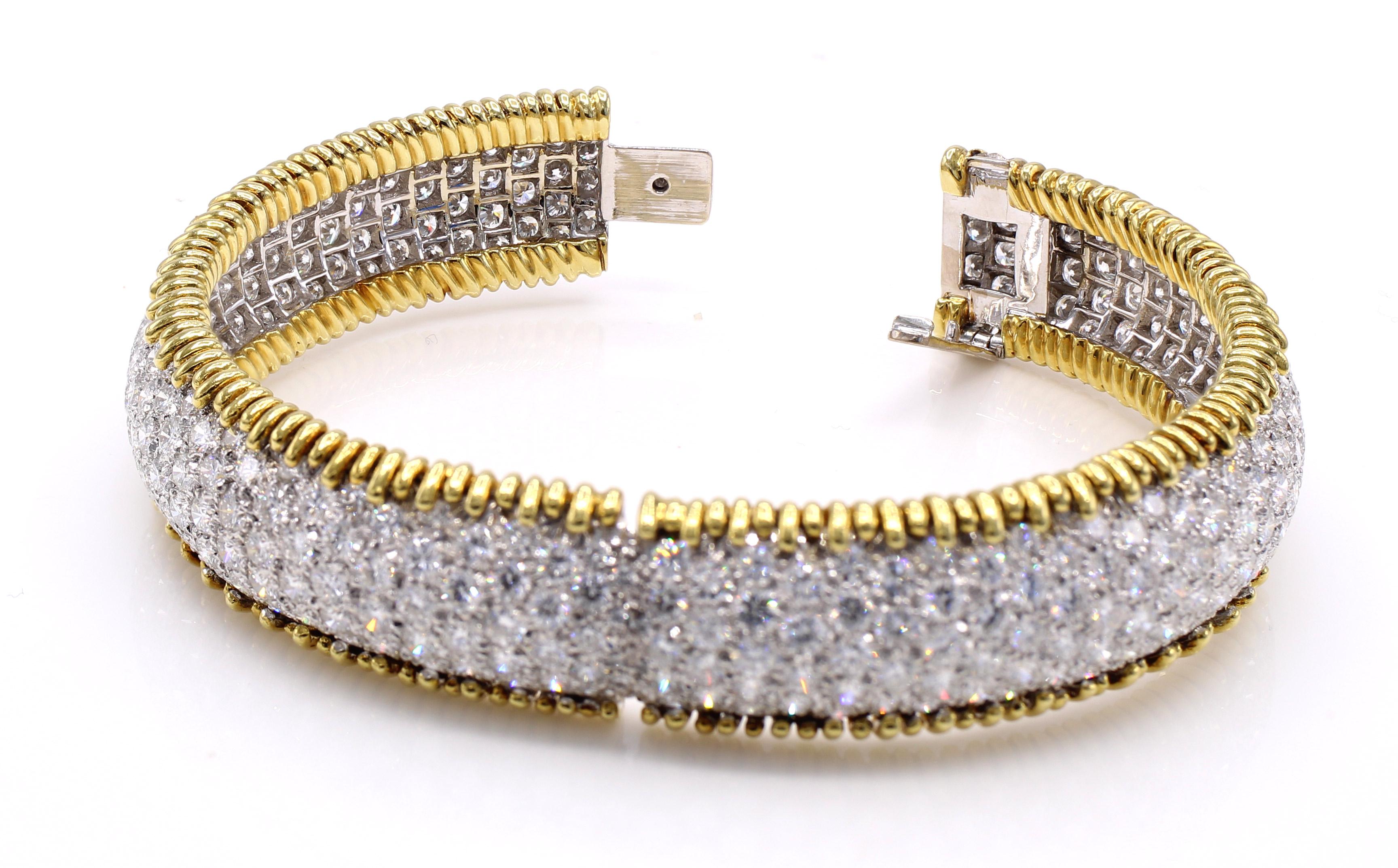 Beautifully designed and masterfully handcrafted in platinum and 18 karat yellow gold, this gorgeous bangle/cuff bracelet displays a river of sparkling white around the wrist. 333 perfectly matched round brilliant cut diamonds are pave set in