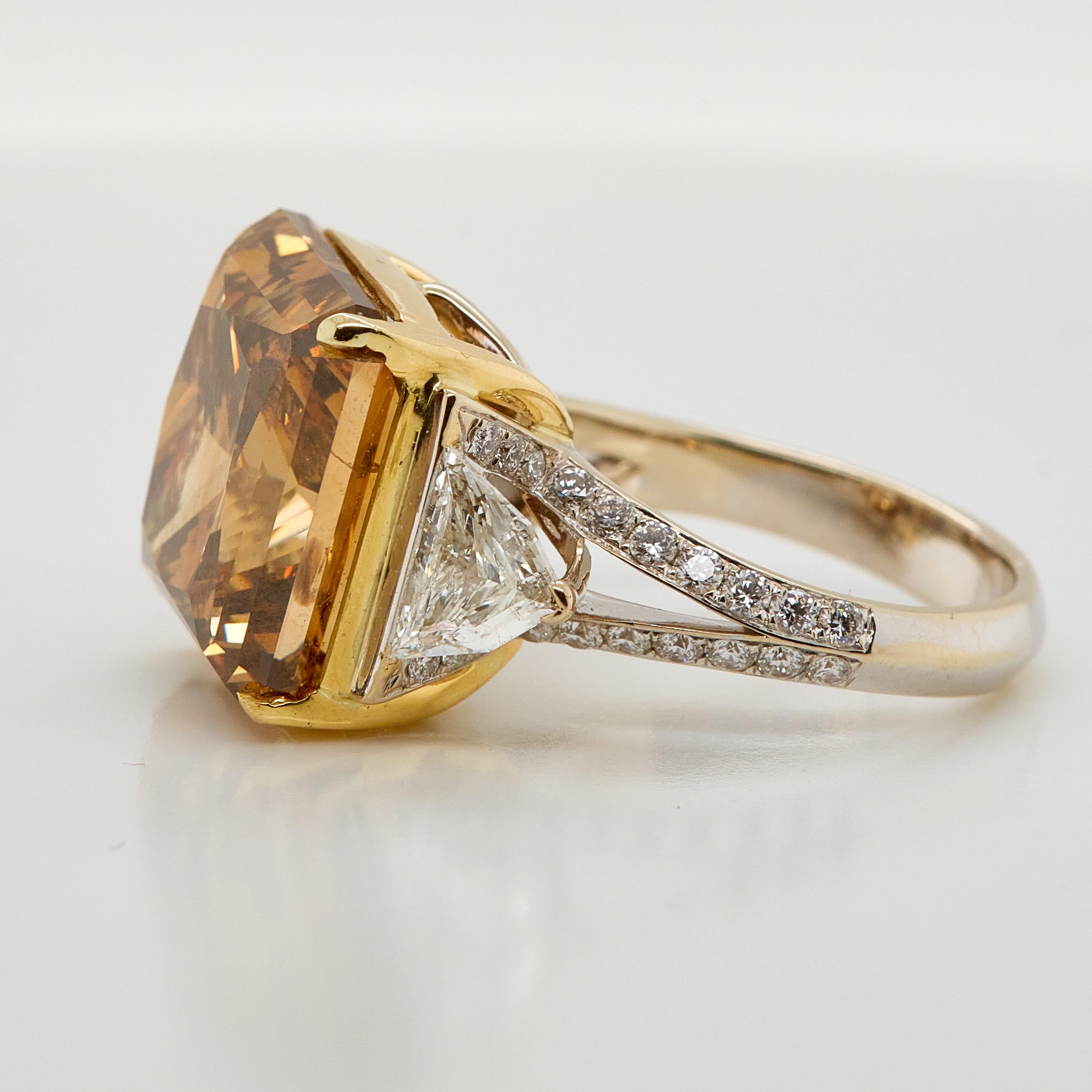 Absolut atemberaubender Verlobungsring mit einem GIA-zertifizierten 20,59 Karat Fancy Deep Brown Orange Diamant im Rechteckschliff. 
Die Größe des Mittelsteins macht diesen Ring zu einem echten Hingucker. Flankiert von zwei Diamanten im