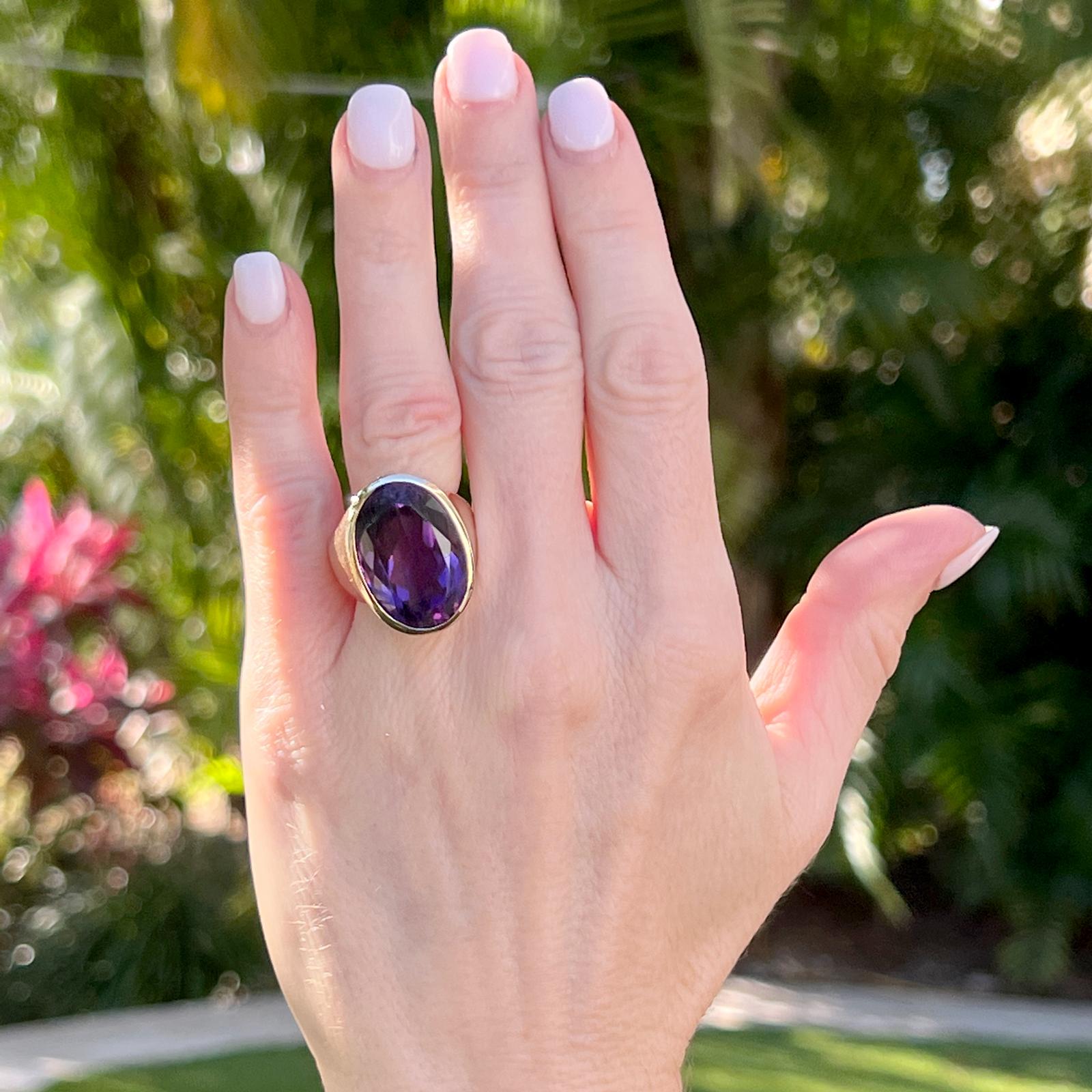 Ovaler Amethyst-Cocktailring mit Lünettenfassung aus 14 Karat Gelbgold. Der ovale natürliche Amethyst wiegt ca. 20 Karat und ist in einen massiven einfachen Gelbgoldring eingefasst. Die Spitze misst 15 x 20 mm, und der Ring hat derzeit die Größe 8
