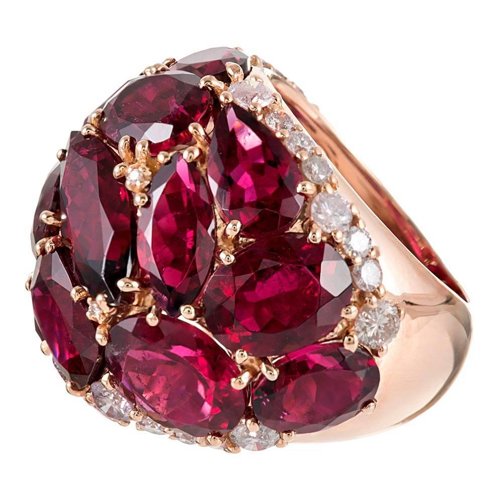 Warm hues of magenta rubellite are peppered with brilliant white diamonds atop a polished mounting of 18 karat rose gold. The ring boasts playfulness and mid-century-inspired character in addition to its 20 carats of tourmaline and .70 carats of