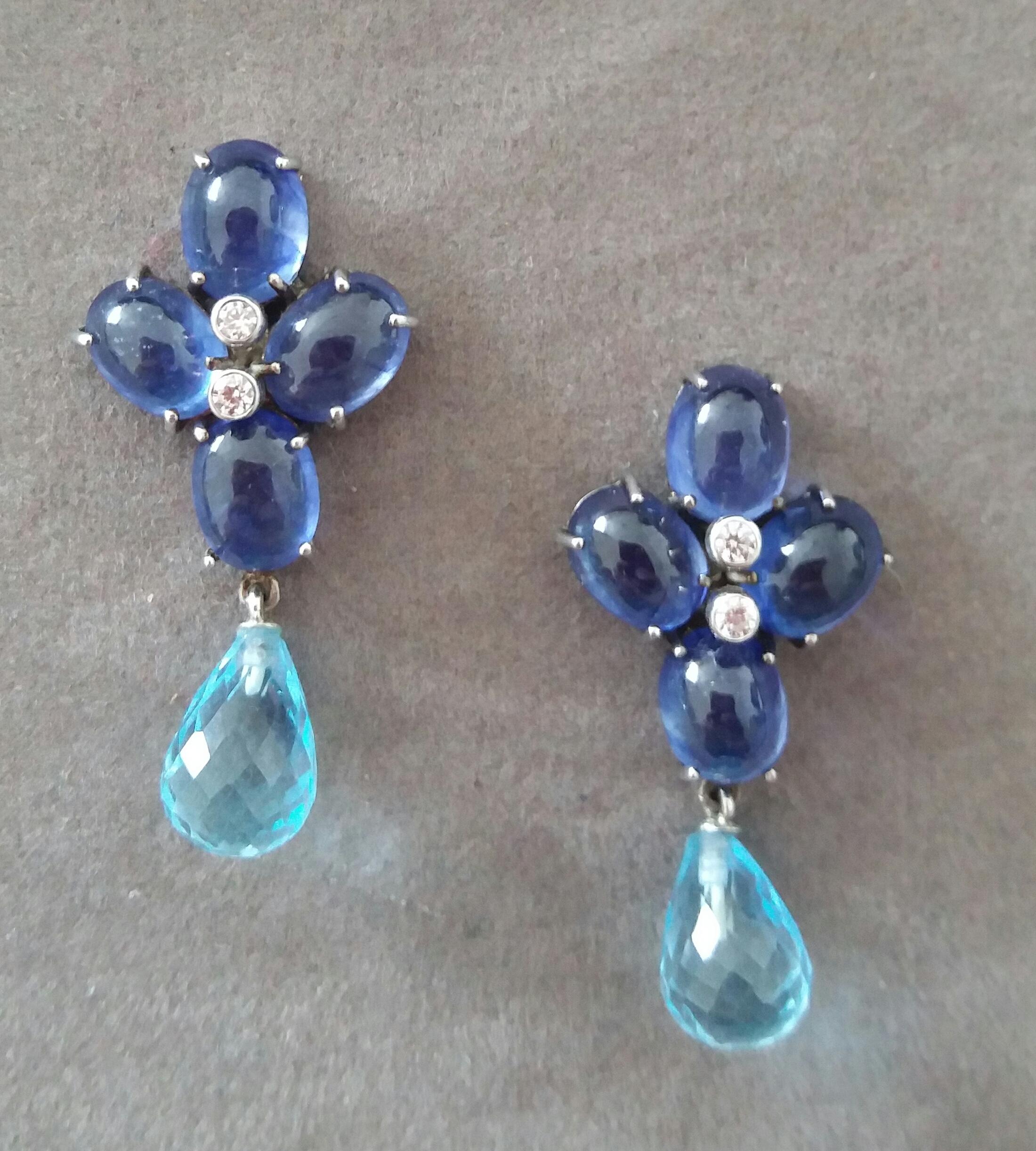 Elegant and completely handmade Earrings consisting of an upper part of 4 oval shape Blue Sapphires 6x8 mm  and weighing 20 Carats set together in 14 Kt white gold with 2 small diamonds in the center, at the bottom we have 2 Faceted Sky Blue Topaz