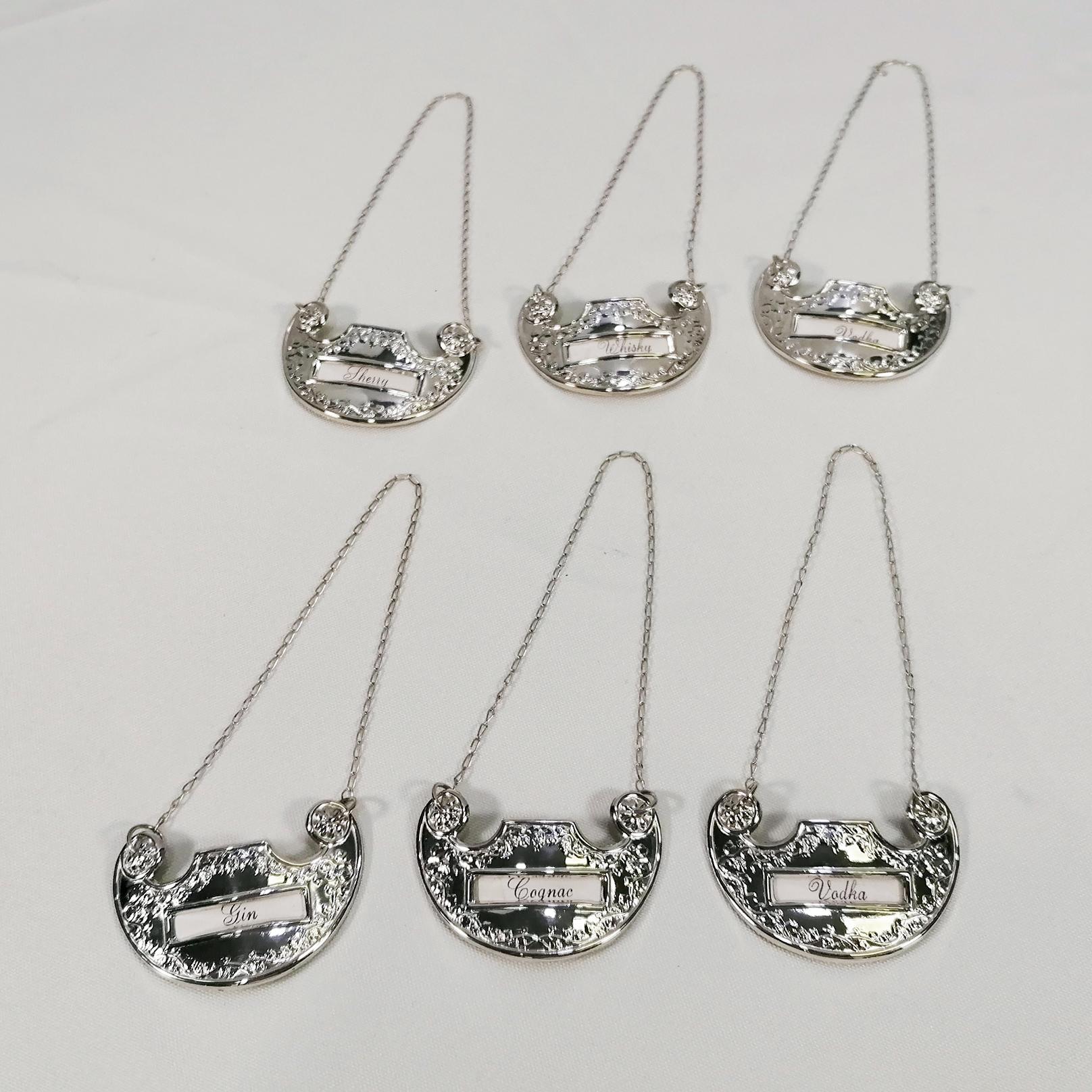 The six labels are shaped in the Italian Baroque style. 
A small window has been made in each label where you can add a card with your favorite liqueur.
Two small holes have been made on the upper sides where a chain has been fixed to ensure that