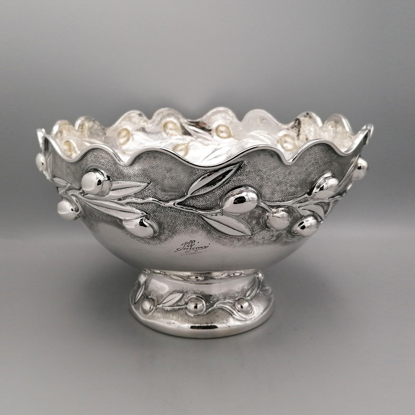 Centerpiece/bowl in solid 800 silver made entirely by hand.
The body of the bowl is rounded with the upper part scalloped in waves where a rectangular section edge was subsequently welded to ensure that the edge itself is not 