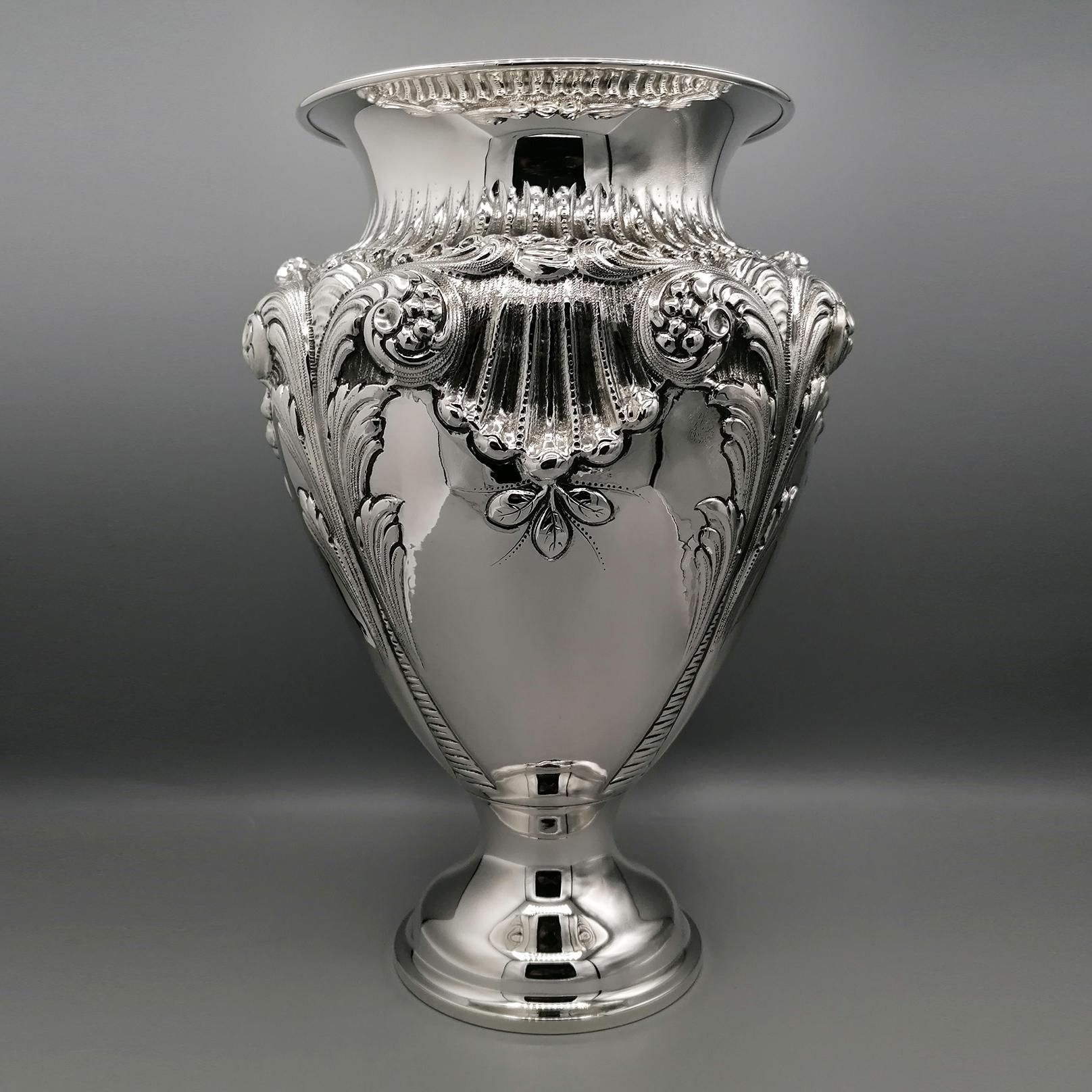 Large baroque style sterling silver vase.
The body of the vase has been masterfully embossed with shells, flowers and volutes, typical of the Baroque style.
Still in the body of the vase, some parts have been left shiny to highlight the great