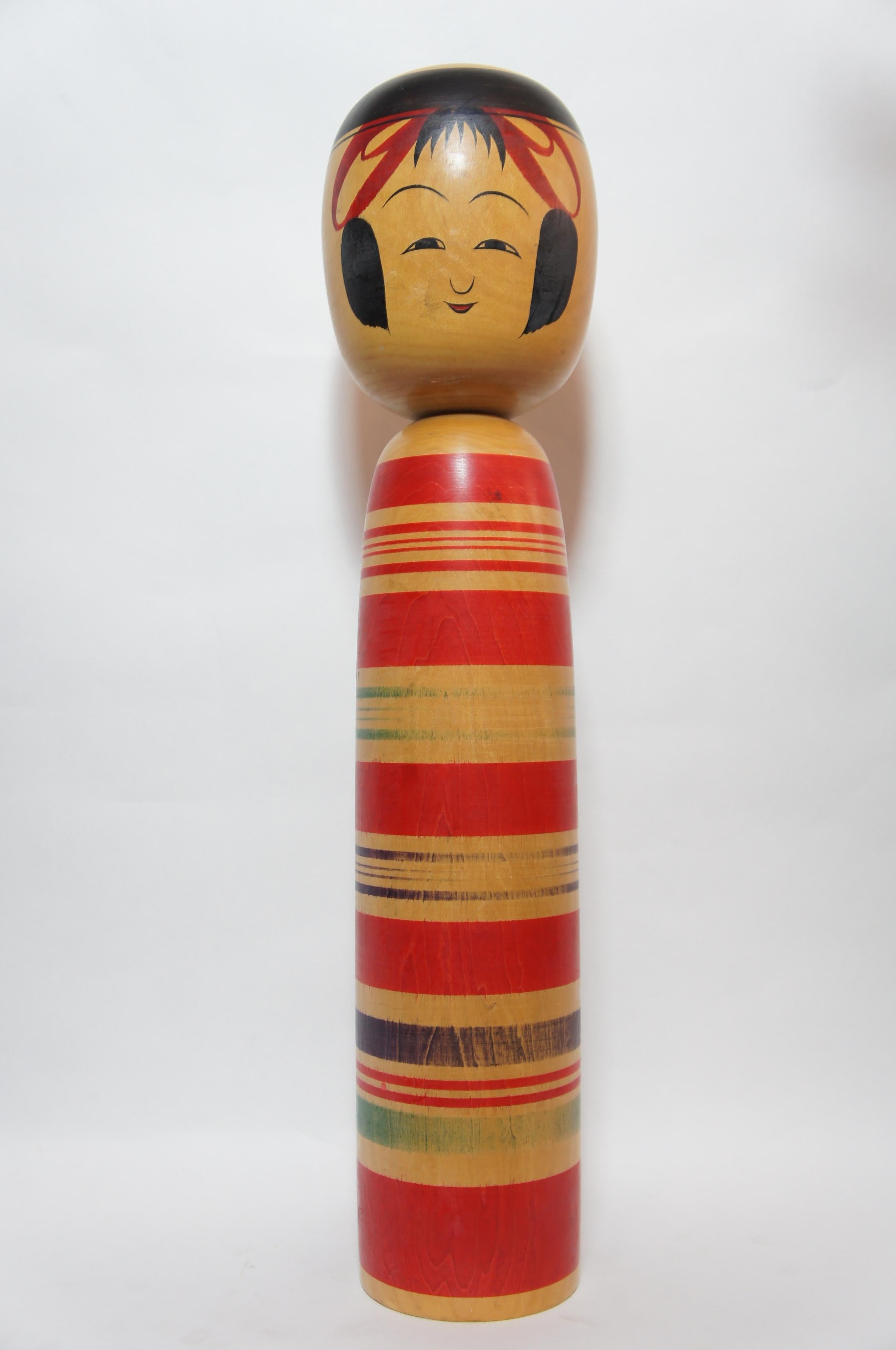 Japanese traditional kokeshi doll signde by Tokunaga Shinichi(1933-).
He is on of the kokeshi artists from Tsuchiyu-onsen, Fukushima, Japan.

The style of this Kokeshi called Tsuchiyu style is on of 11 types of Kokeshi and is one of three most