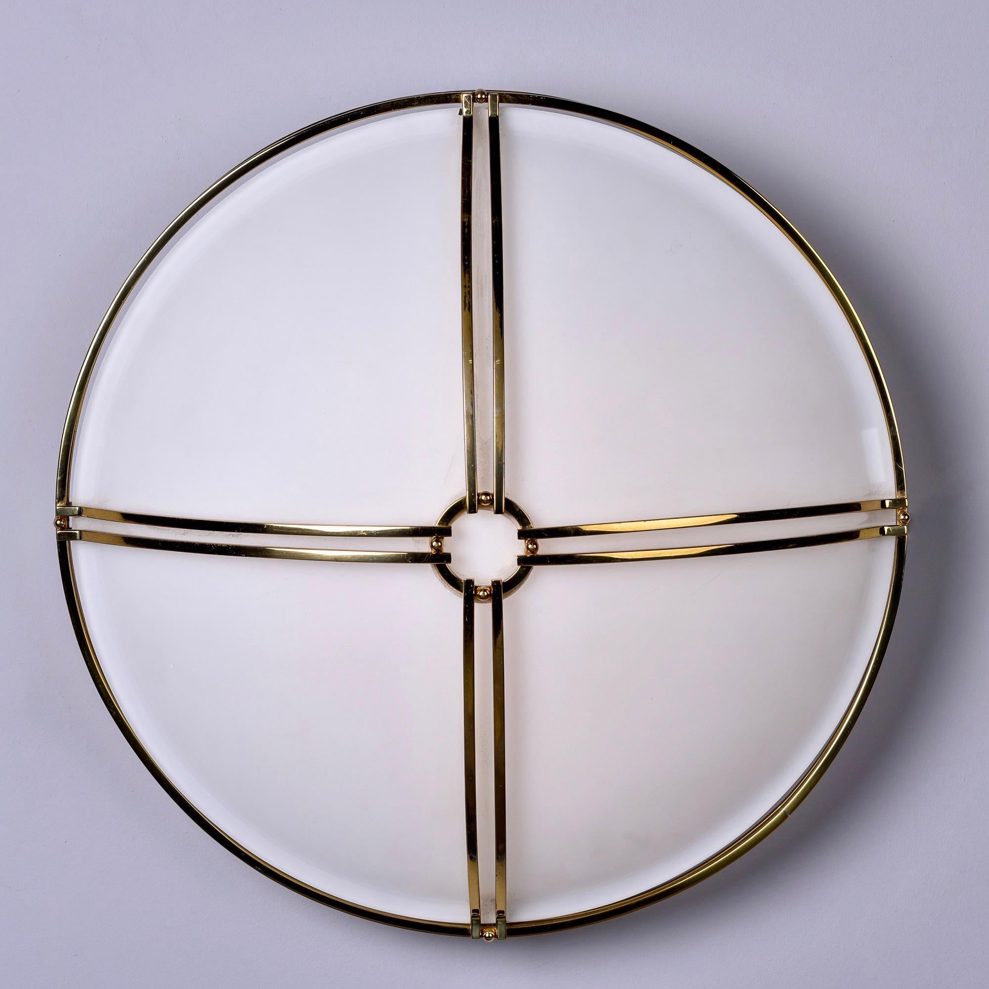 Boyd Lighting large flush mount fixture is 20” in diameter and features four standard sized sockets under white satin glass globe. Fixture is trimmed in a double strand brass X-Form overlay with a ring at the center. Simple and chic. Excellent