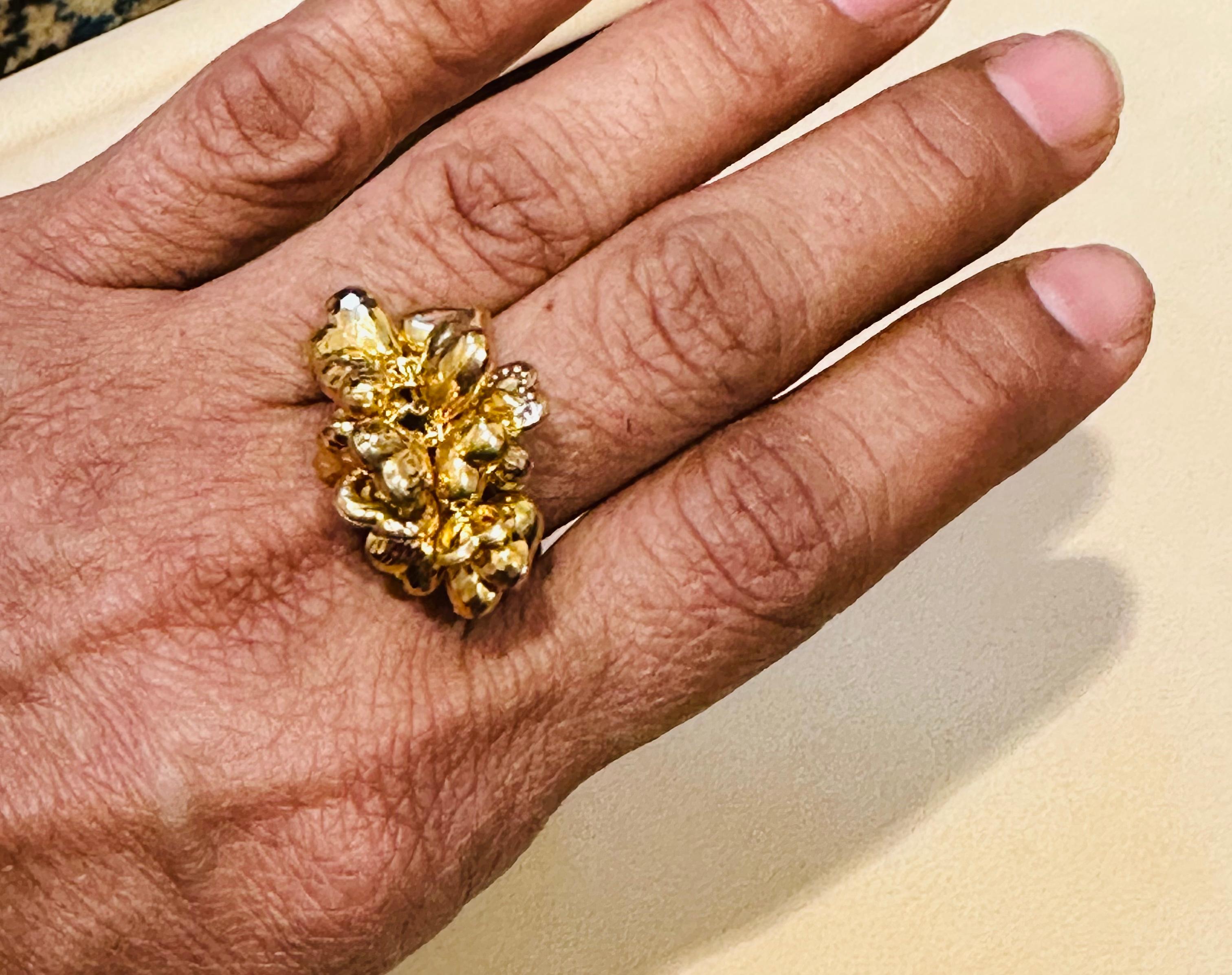 This 14 karat yellow gold ring features close to 20 different heart charms, all with unique shapes and bunched together on top of a band. This vintage ring is a beautiful piece of jewelry that boasts a stunning color and shine. The ring weighs 4.1