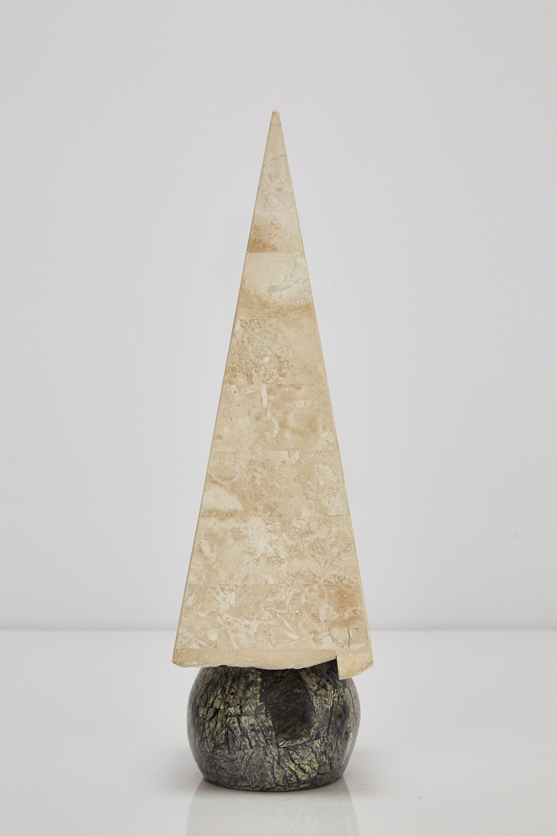 20 in. tall decorative obelisk. The pyramid executed in tessellated beige fossil stone and round base executed in Serpentine stone. 

Coordinates with items LU1484211449881 and LU1484211449861 for a set of three.

All furnishings are made from 100%