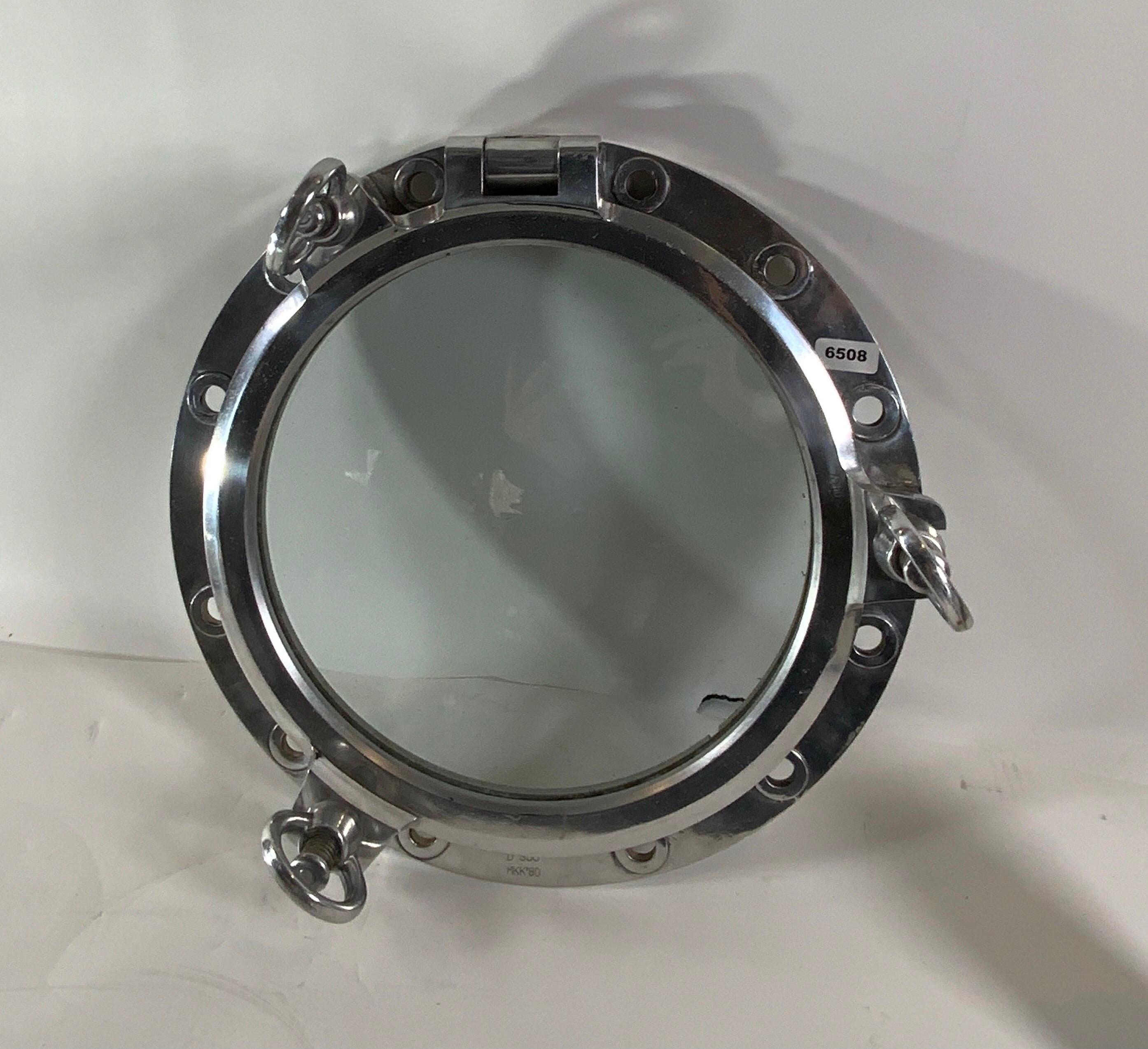 Authentic polished aluminum ship's porthole fitted with glass. Door is hinged and fitted with three dogbolts. The highly polished porthole is ready for display.

Overall dimensions: glass diameter: 14