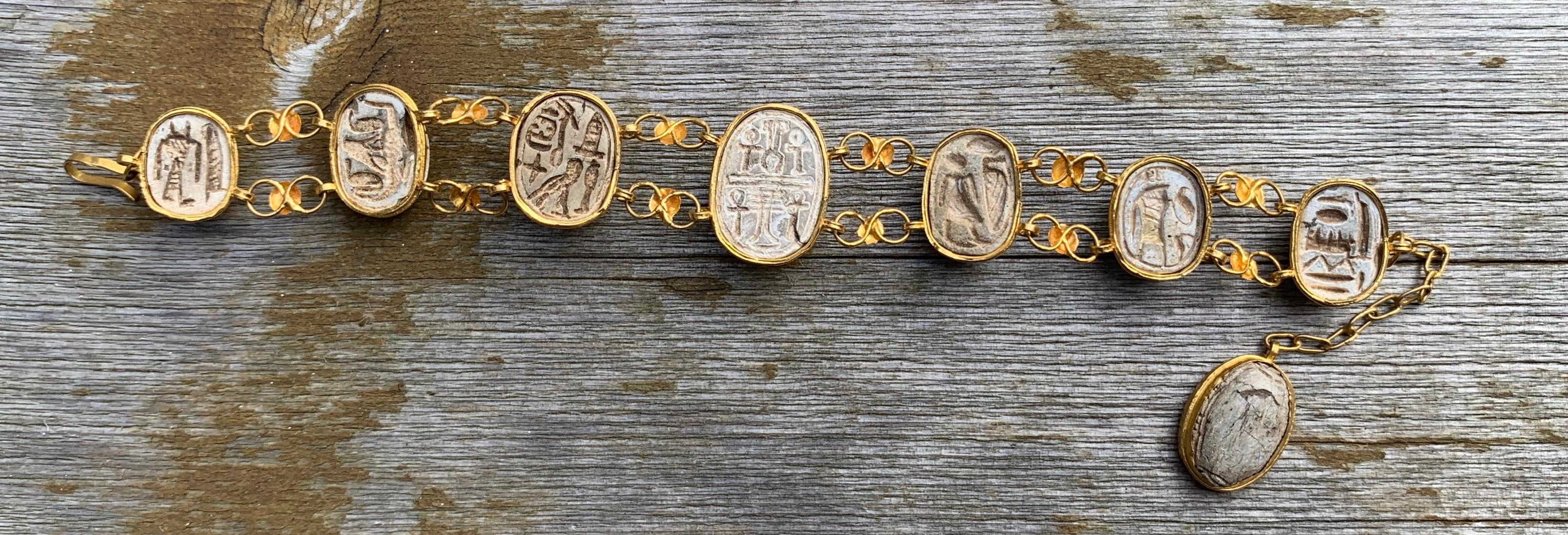 This is a very rare and wonderful antique Egyptian Revival Bracelet with eight graduated Scarab Beetles set in 20 Karat Yellow Gold with Hieroglyphics on the reverse of the Scarabs. The gorgeous scarabs are hand carved Sandstone. The scarabs are