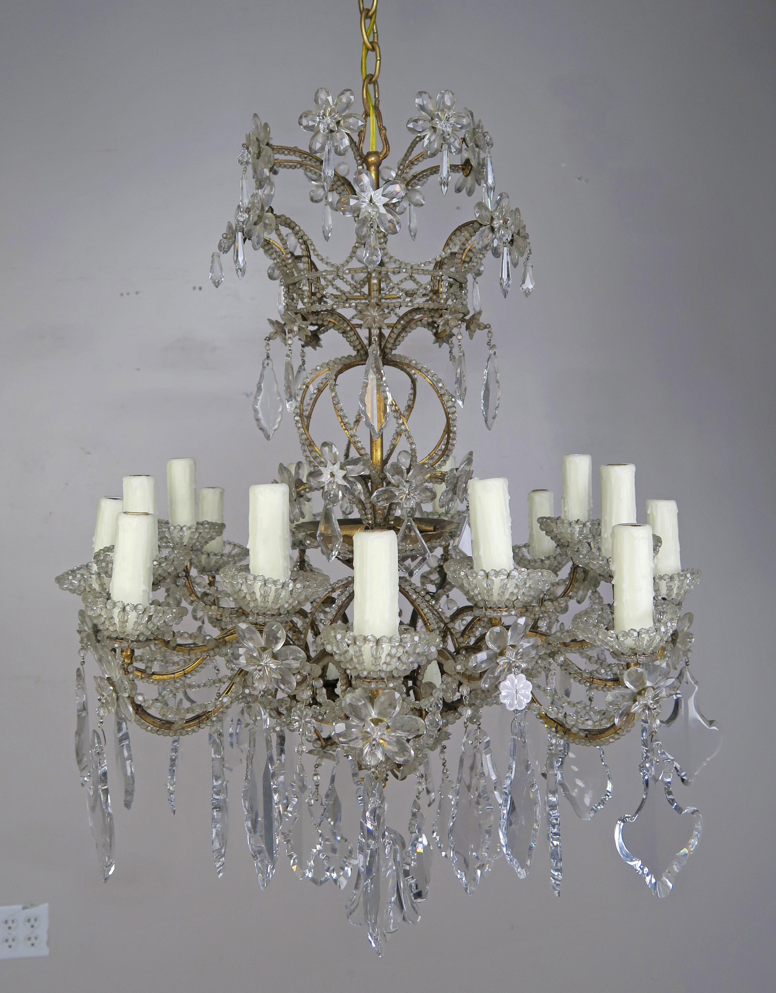 20-light Italian crystal beaded chandelier with crystal flowers and etched crystals throughout. The crystal beaded body of the fixture swirls up into a large bouquet of crystal flowers. The chandelier is adorned with star etched crystals in various