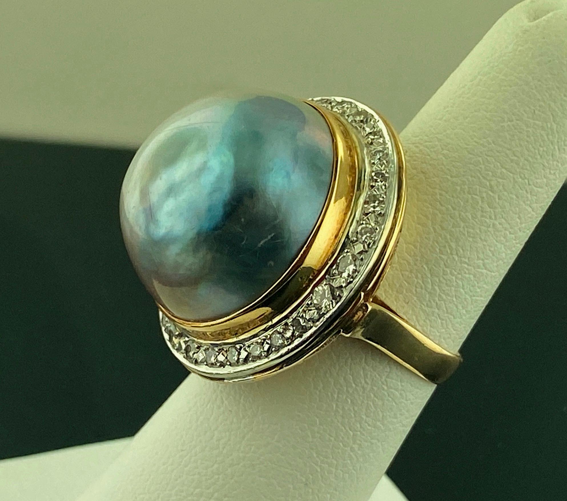 Set in 14 karat yellow gold is one 20 mm MABE Pearl, blue-gray in color, with 24 Round brilliant cut diamonds weighing approximately 0.50 carats.  Ring size is 5.5